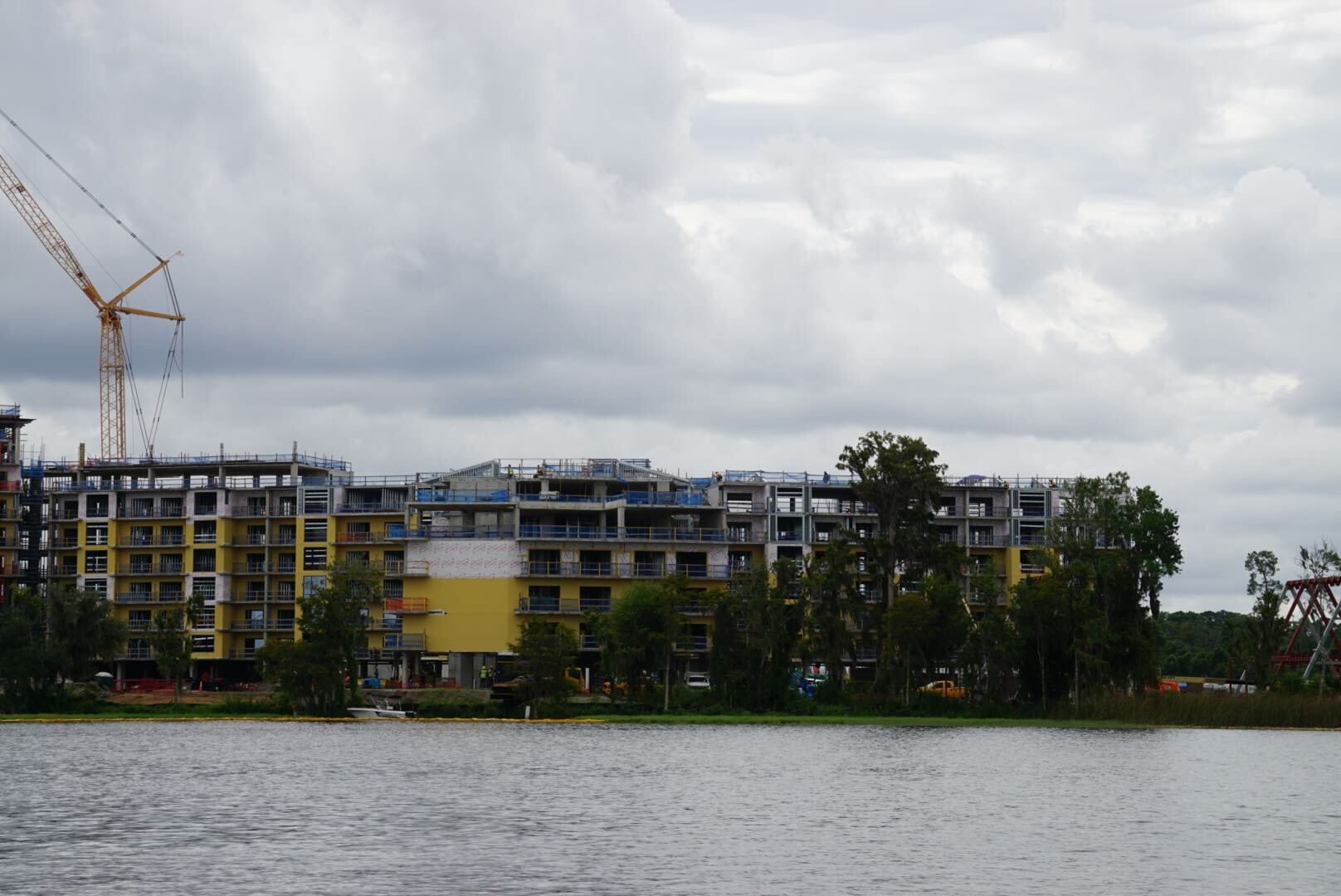 Lakeshore Update: A large building under construction near water, with a crane and cloudy sky overhead.