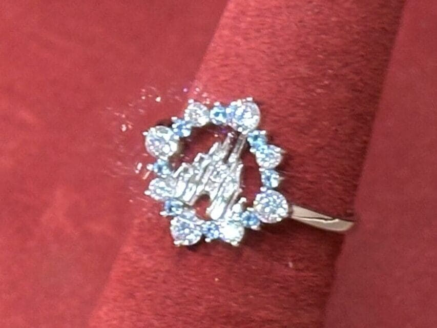 A fine jewelry diamond cluster ring displayed on a red stand with a price tag showing $135.