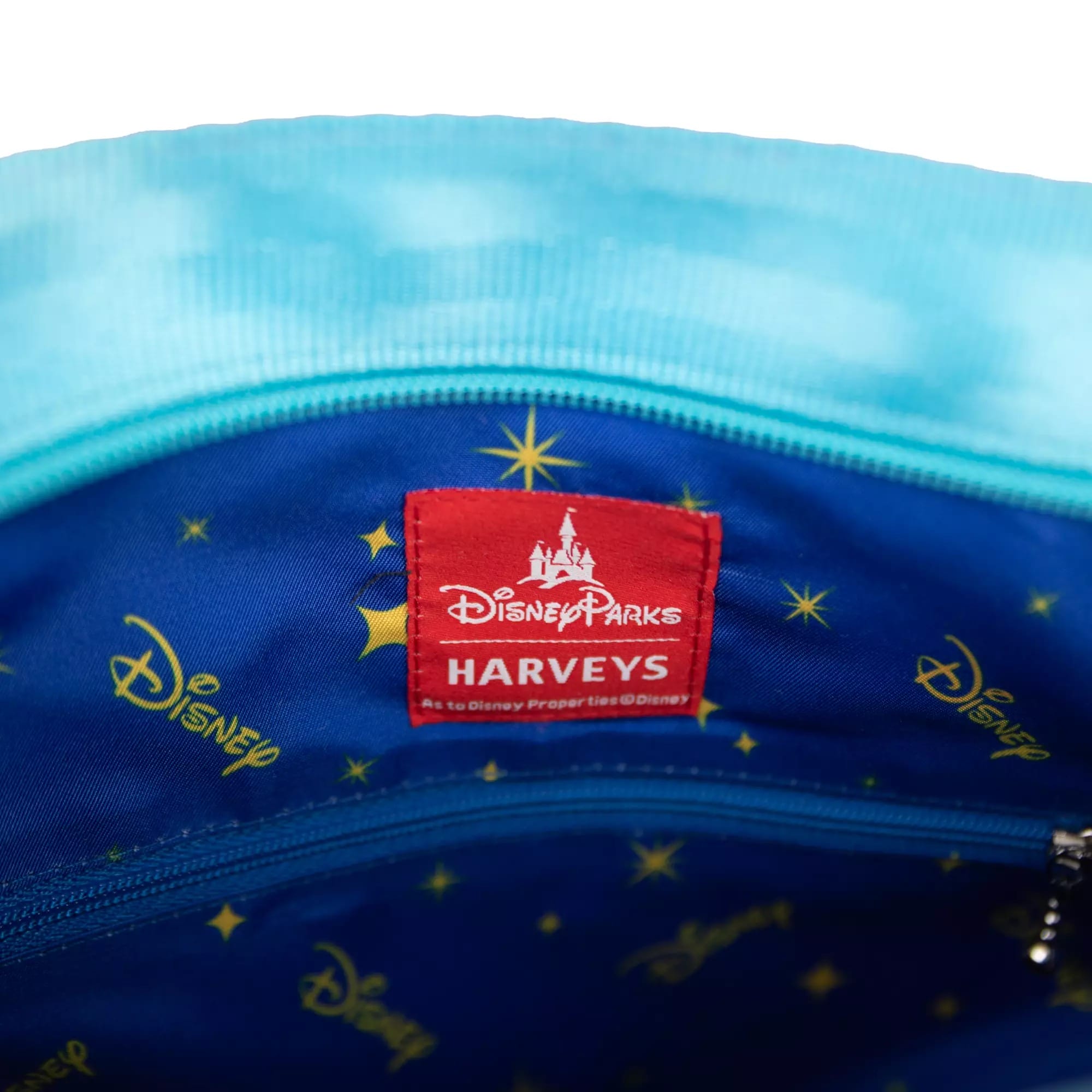 Close-up of a blue Disney Parks x Harveys bag interior with a red label, star lining, and Disney Store exclusivity.