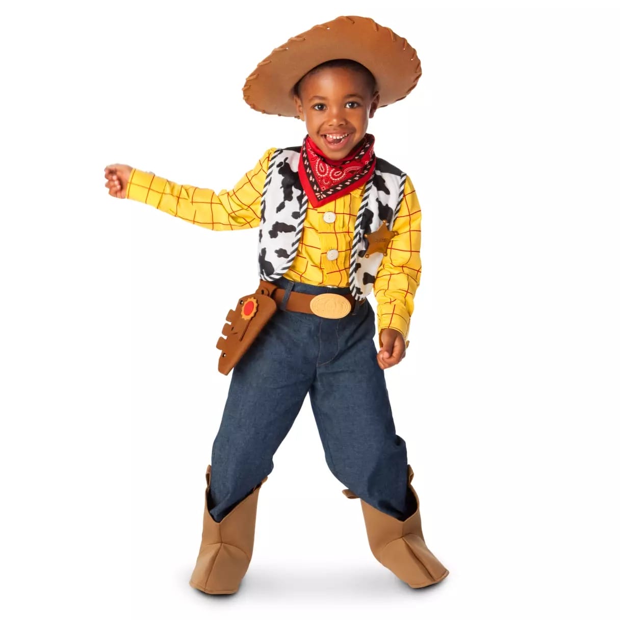 Smiling child in a Disney Store cowboy costume with hat, bandana, vest, jeans, and boots, posing playfully for Halloween.
