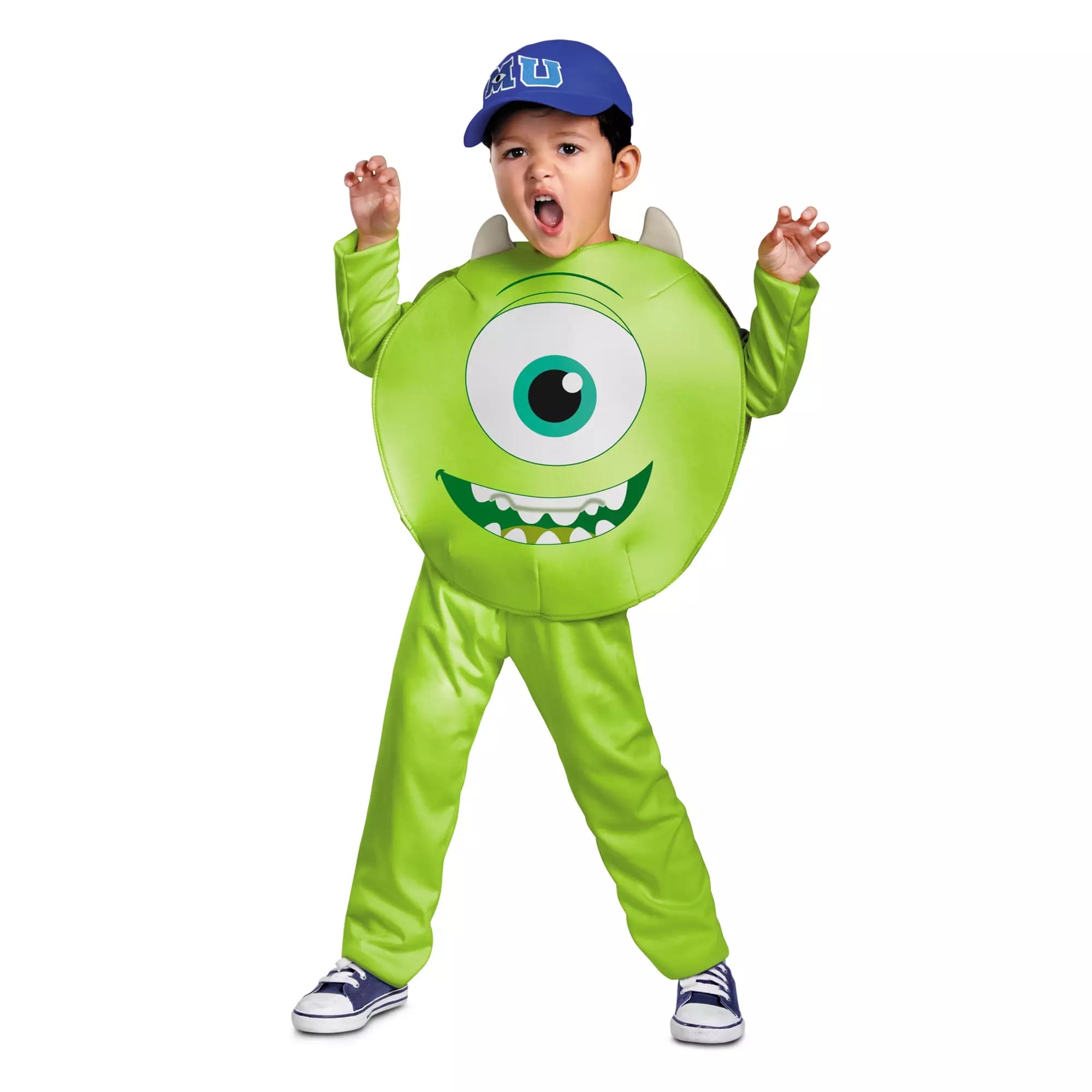Child wearing a green monster Halloween costume with one large eye, raised hands, and a blue cap from Disney Store.
