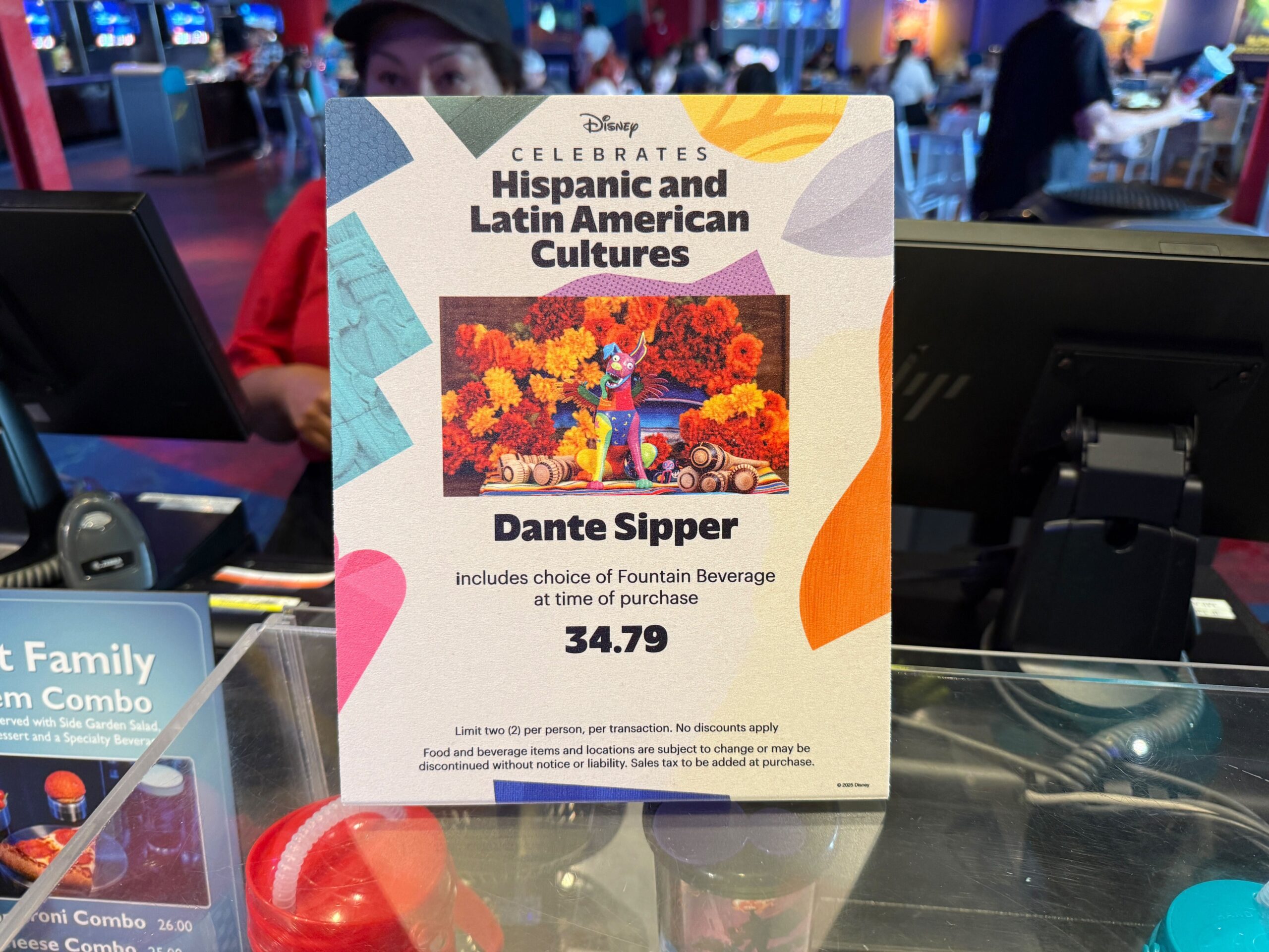 Sign promoting the Dante Sipper cup for $34.79 at Plaza de la Familia, celebrating Latin cultures at Disneyland Resort.