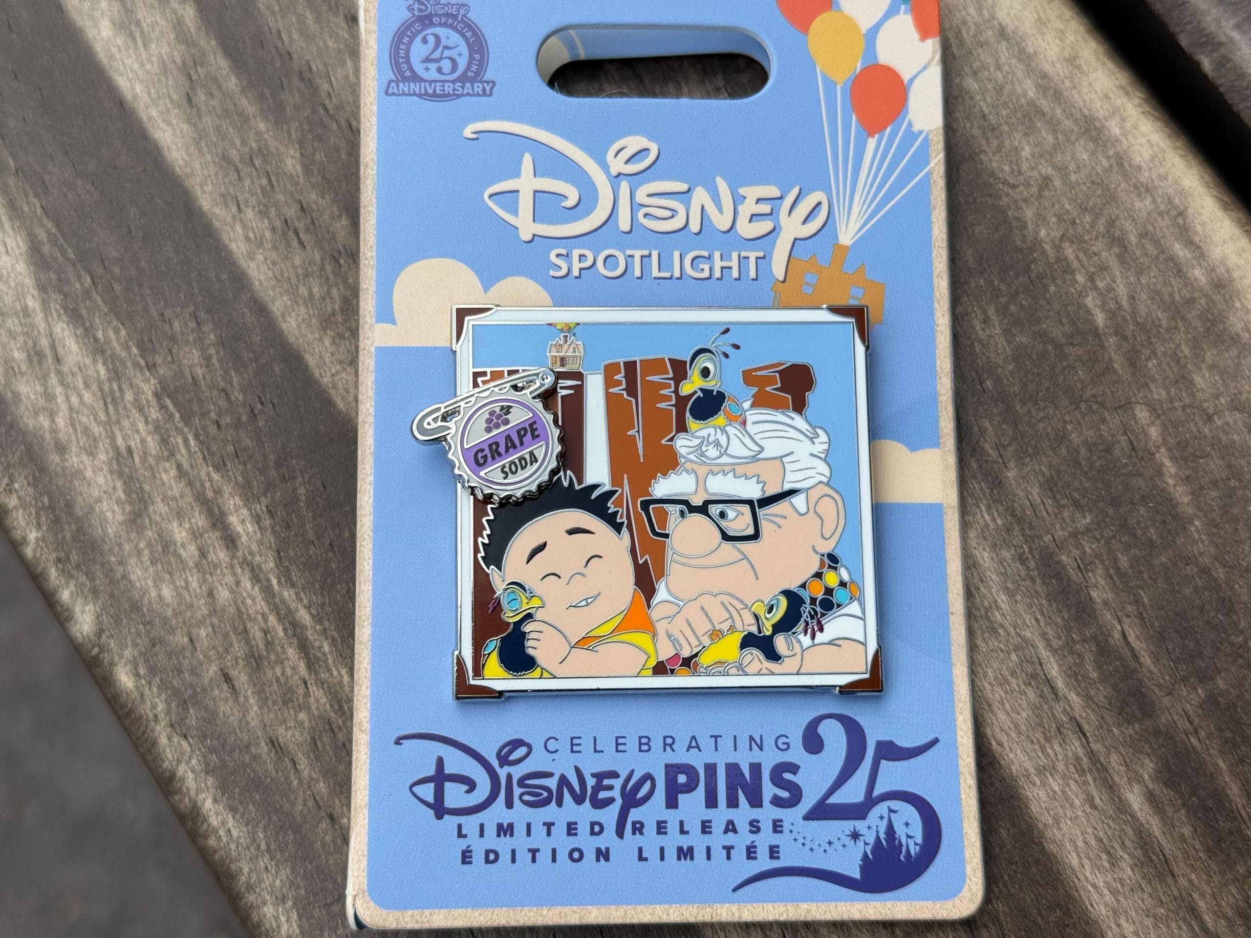 A Disneyland pins collectible featuring Russell, Carl, balloons, and a "Grape Soda" badge on a Disney Pins 25 card.