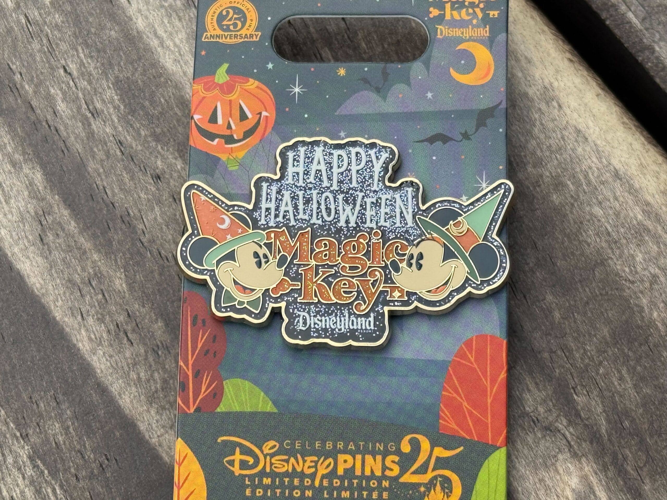 Disneyland pins Halloween Magic Key pin features Mickey and Minnie in hats, pumpkins, and "Happy Halloween" festive packaging.