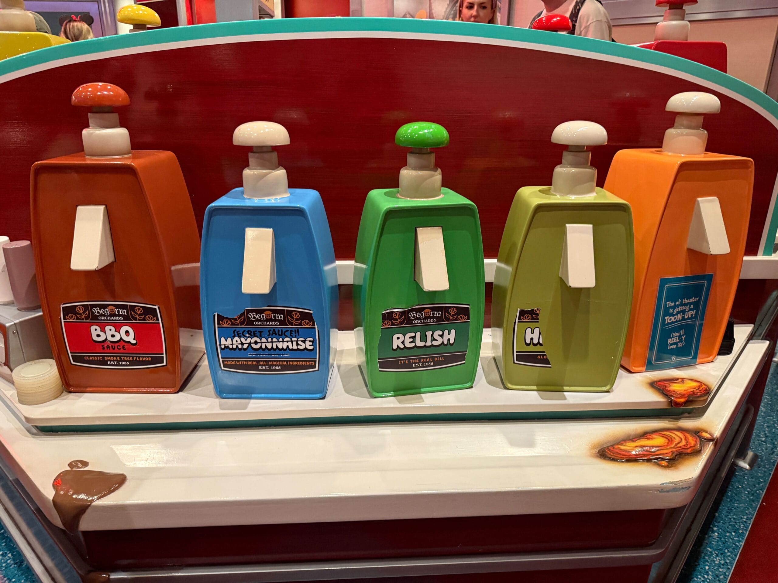 Five oversized condiment dispensers line the counter, like a whimsical sight from Mickey & Minnie's Runaway Railway.