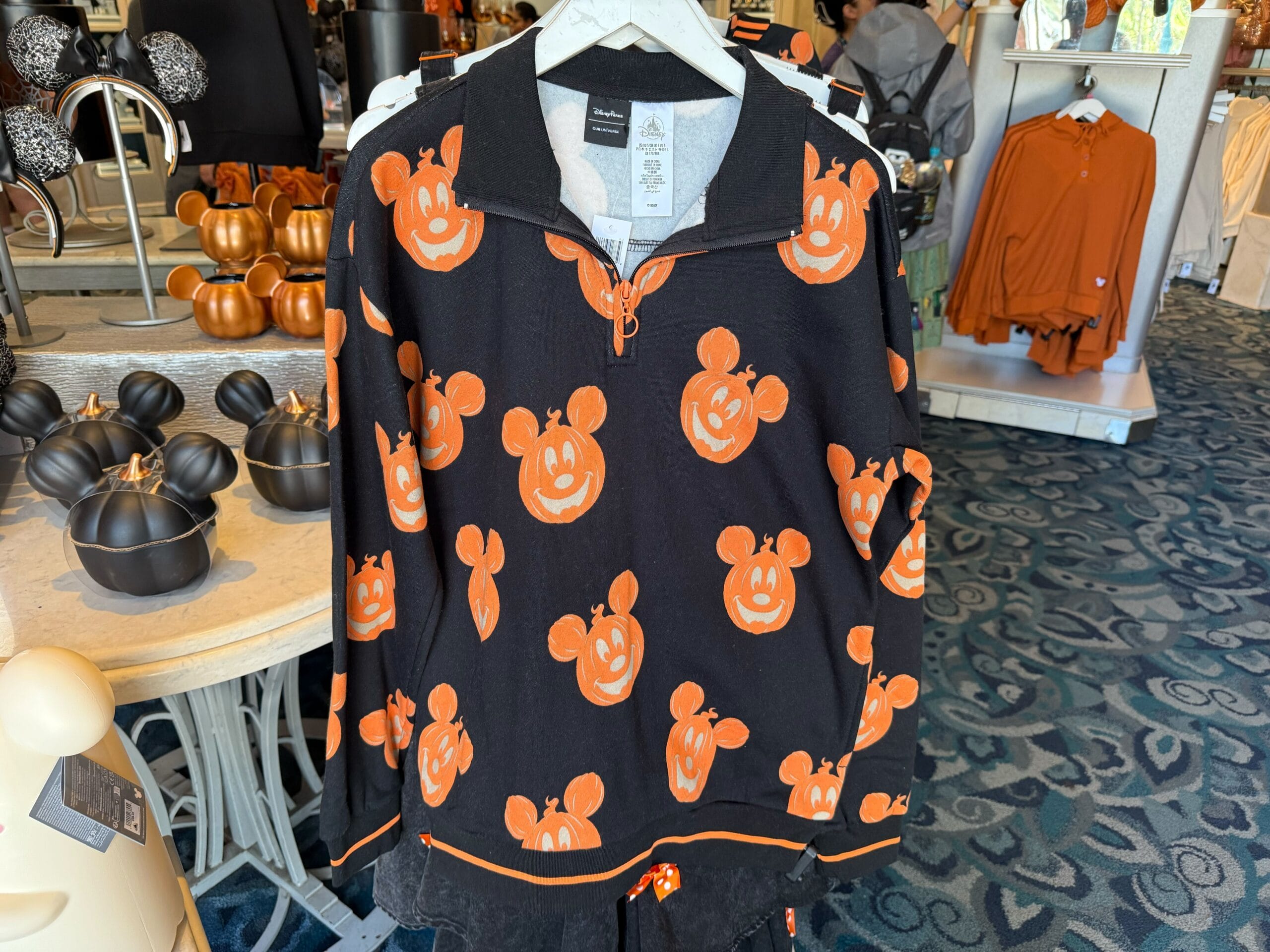 Black pullover featuring orange Mickey Mouse pumpkin faces—perfect 2025 Halloween merchandise at Disneyland Resort.