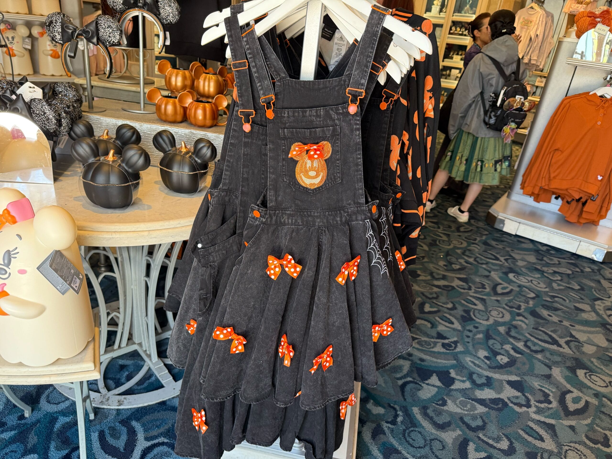 Black overall dress with Minnie Mouse pumpkin patch, part of 2025 Halloween Merchandise at Disneyland Resort.