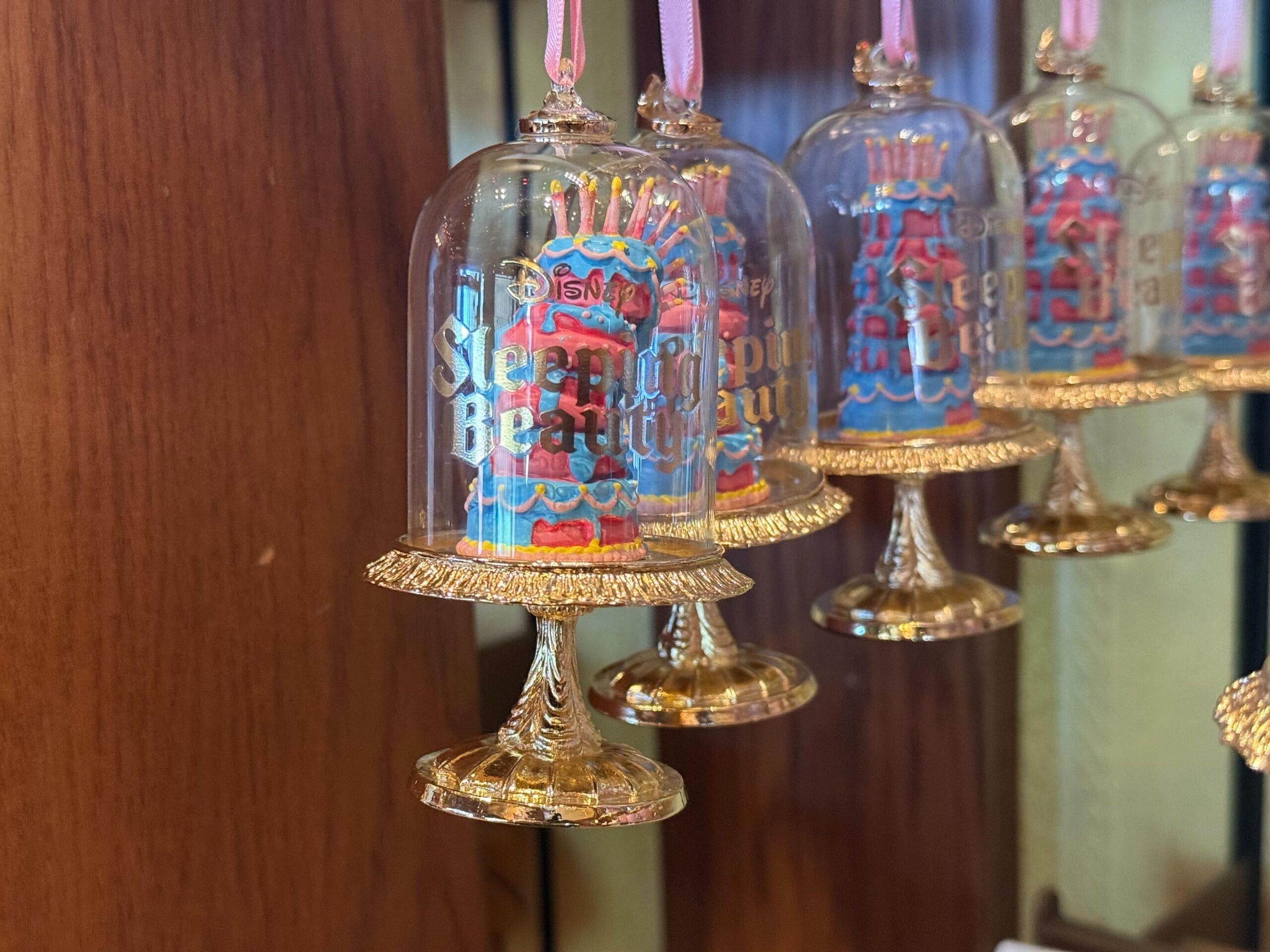 Glass ornaments shaped like cake stands with "Sleeping Beauty" cakes, from the Sugarplum Princess Ornament Collection.