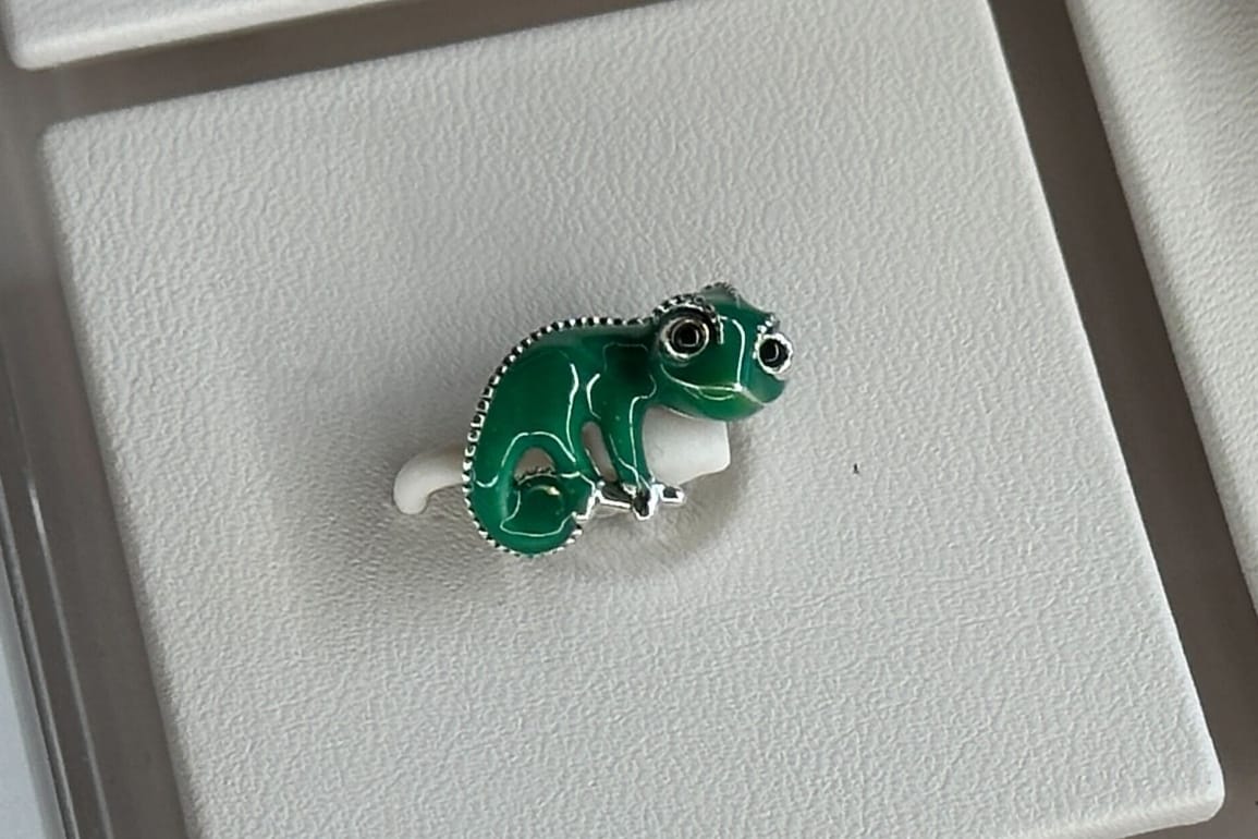 Close up of green and silver Pascal chameleon charm from Pandora's Tangled collection.