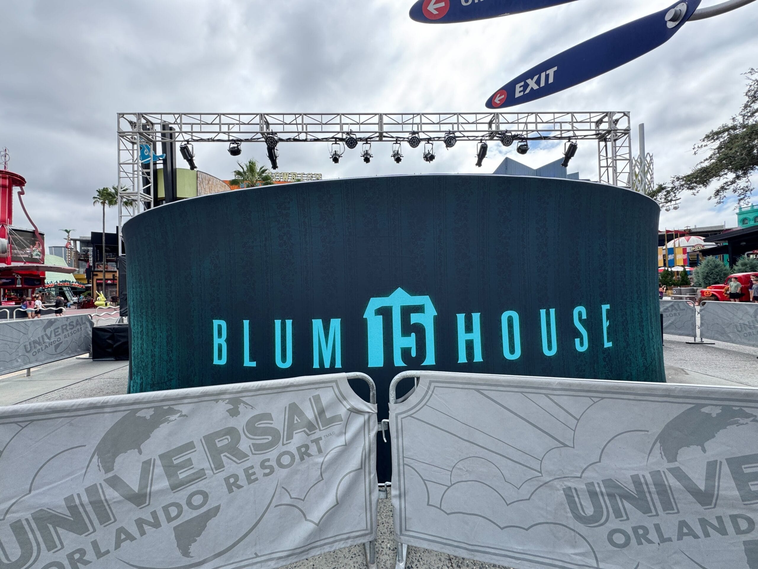 Outdoor display for "Blumhouse 15" at Universal Orlando Resort, with barricades and overcast sky in the background.