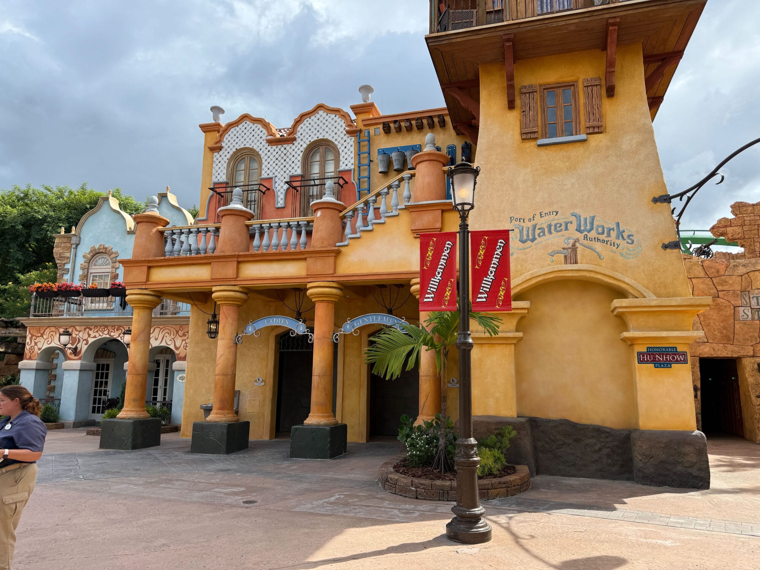 Colorful, Spanish-style Port of Entry Restrooms at Universal Islands of Adventure with “Water Works” sign and palm tree in front.