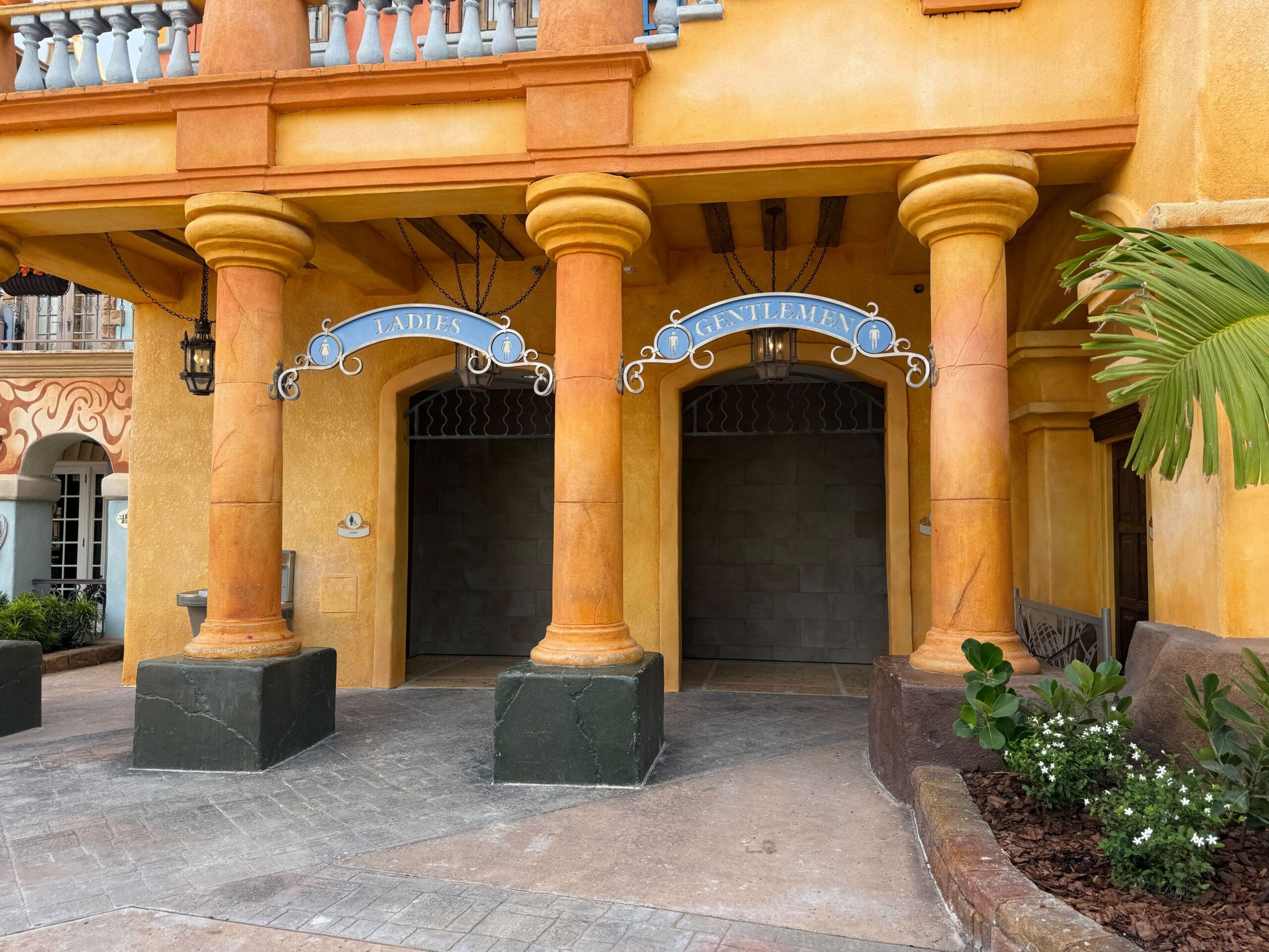 Outdoor Port of Entry Restrooms labeled "Ladies" and "Gentlemen" at Universal Islands of Adventure.