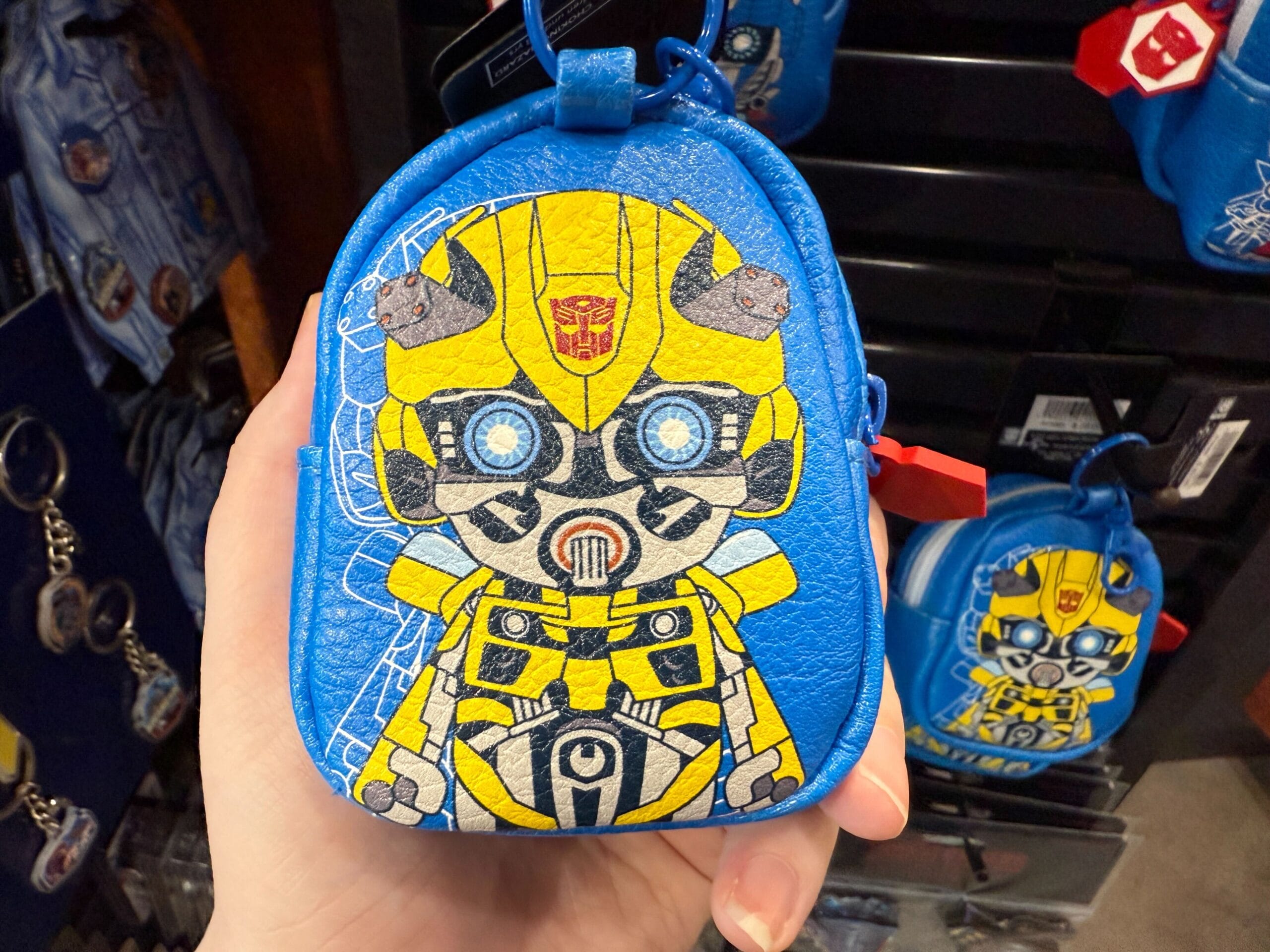 A small blue pouch with a cartoon Bumblebee Transformer design held in someone's hand.