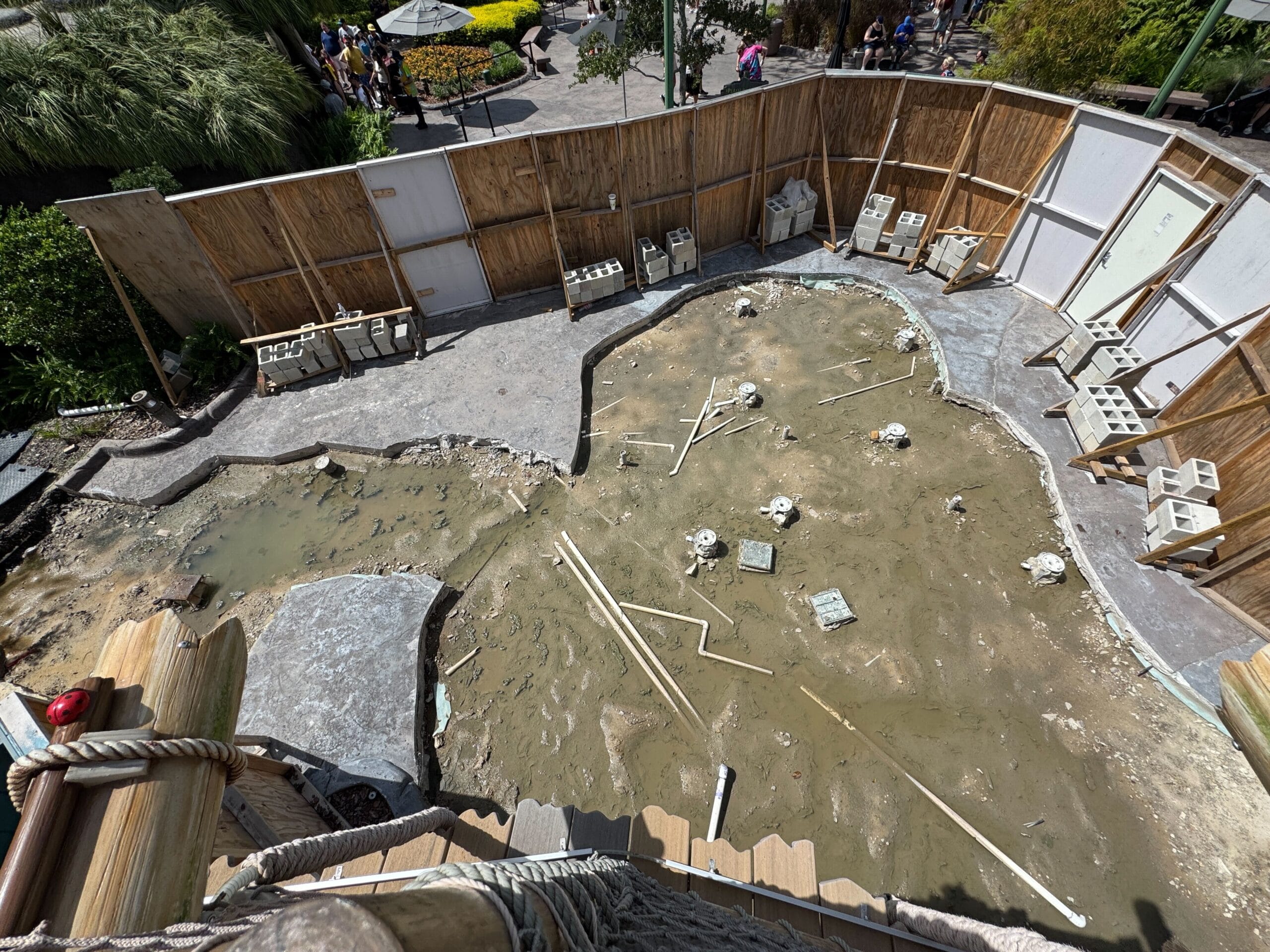 A fenced-off muddy area with bones and tools, like a Shrek-themed dig site at Universal Studios Florida.