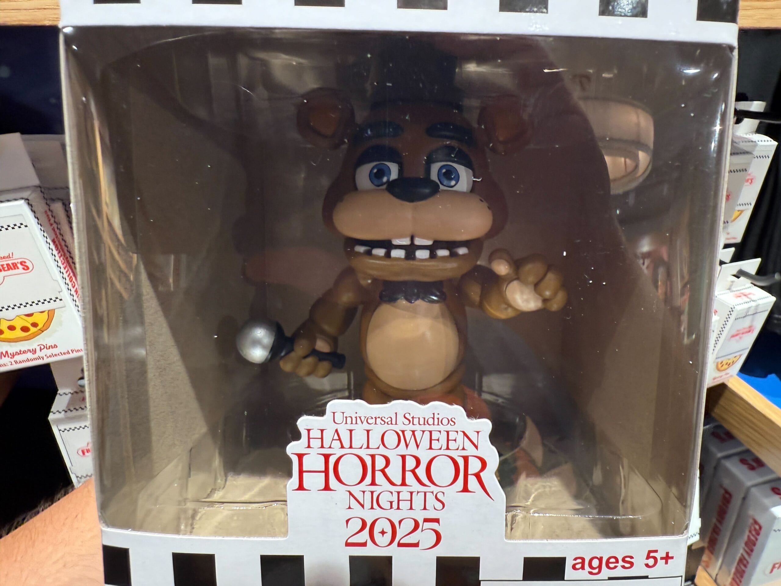 A Five Nights at Freddy's toy figure in a box labeled "Halloween Horror Nights 2025" for ages 5 and up.