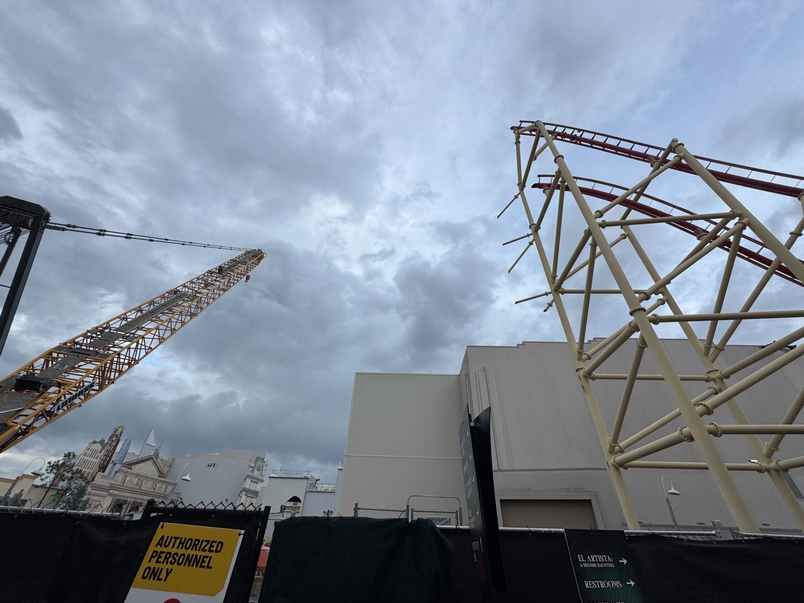 A crane and metal framework rise above demolition at Universal Studios Florida; sign reads "Authorized Personnel Only.
