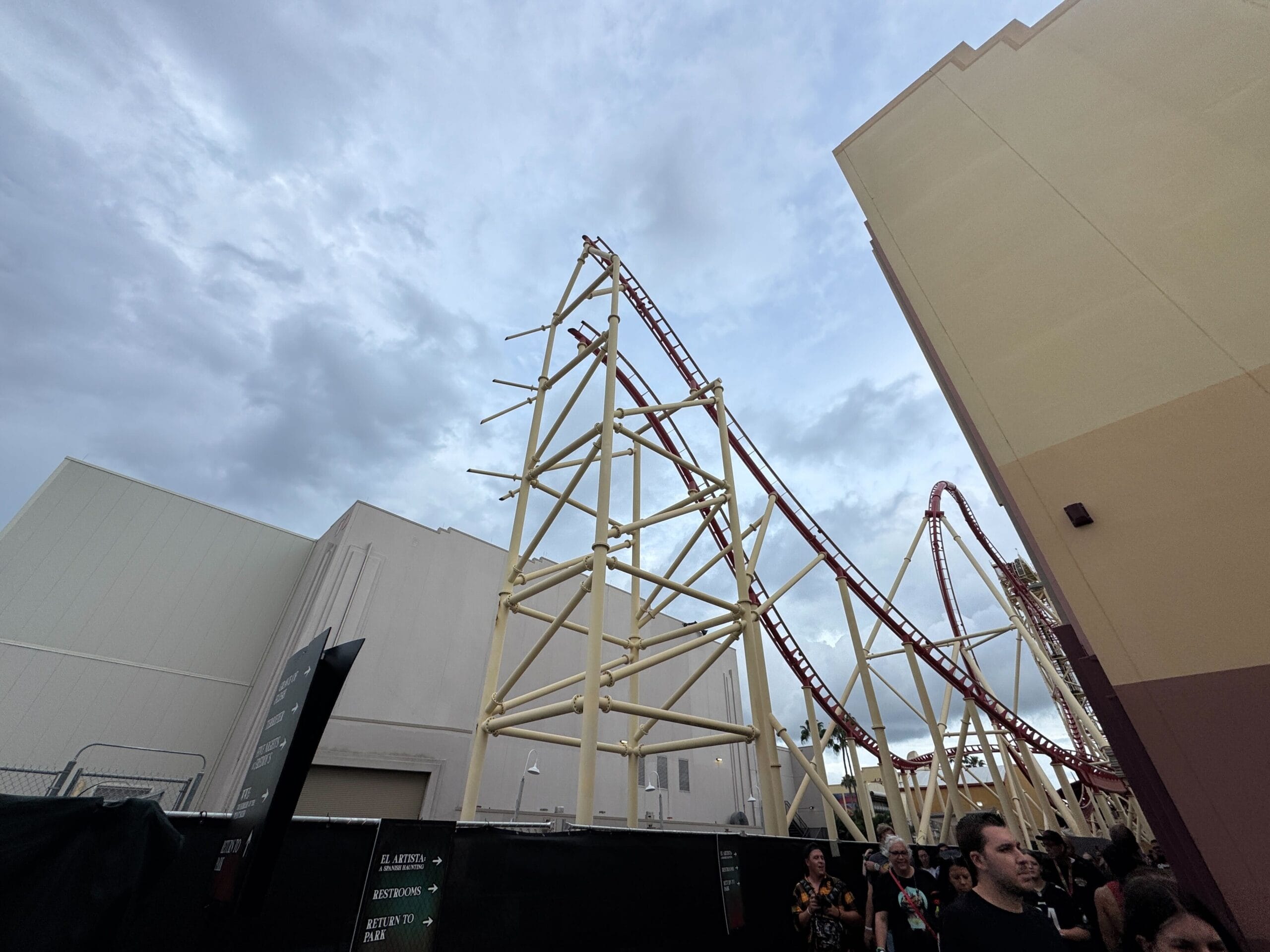 A red Rip Ride Rockit coaster rises above yellow supports at Universal Studios Florida, with crowds gathered below.