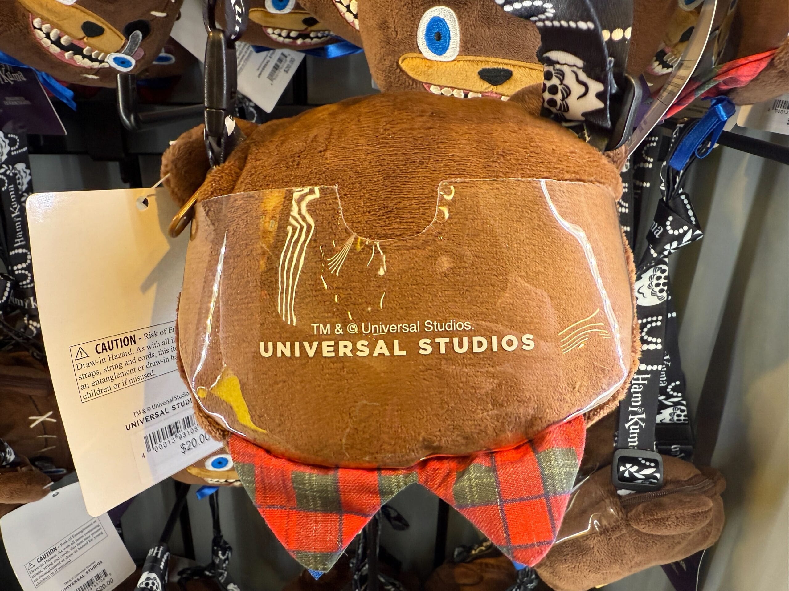 Brown plush keychain with plaid fabric and Universal Studios logo—official HamiKuma Merchandise at Universal Orlando Resort.
