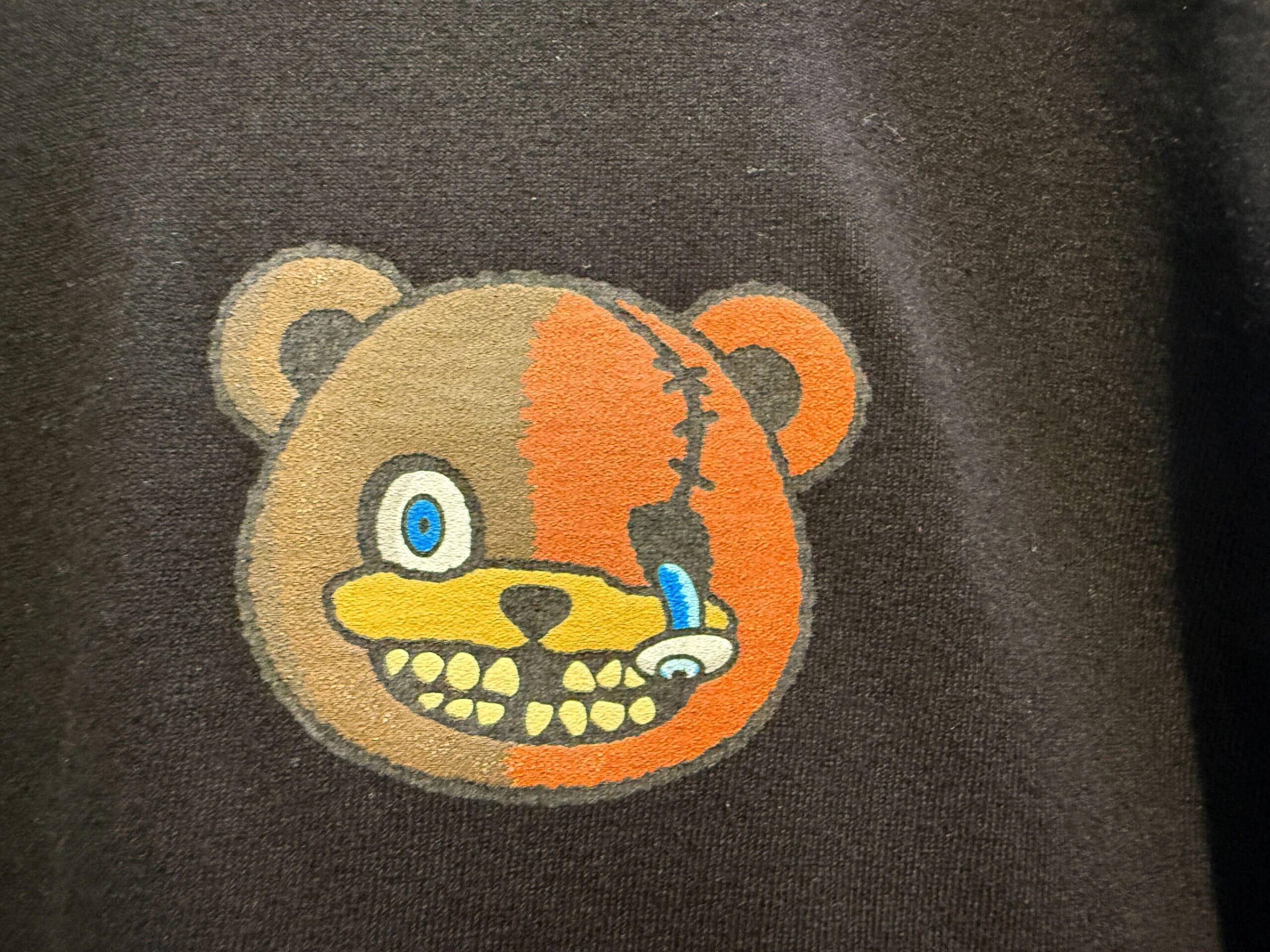 Cartoon bear head, half normal, half robotic, jagged teeth—perfect for HamiKuma Merchandise at Halloween Horror Nights 2025.