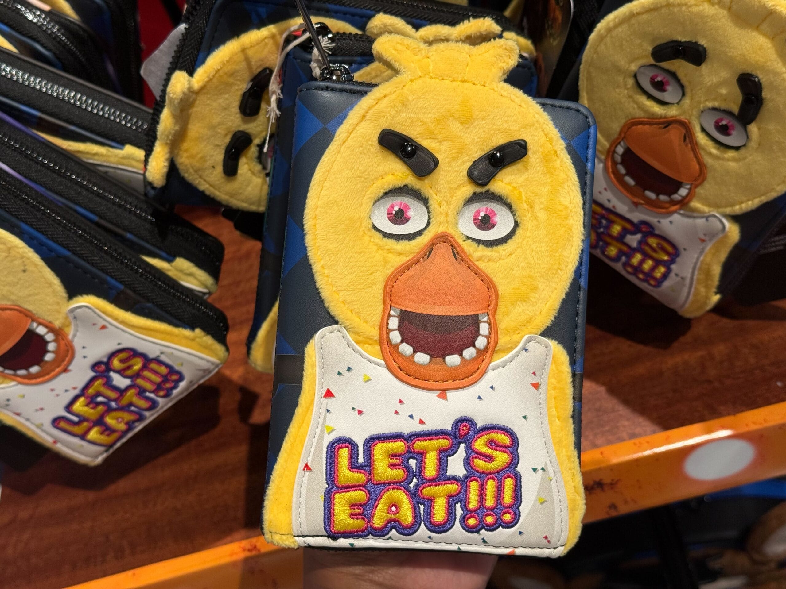 A wallet with a plush yellow cartoon chicken face—an adorable addition to your Halloween Horror Nights Merchandise collection.