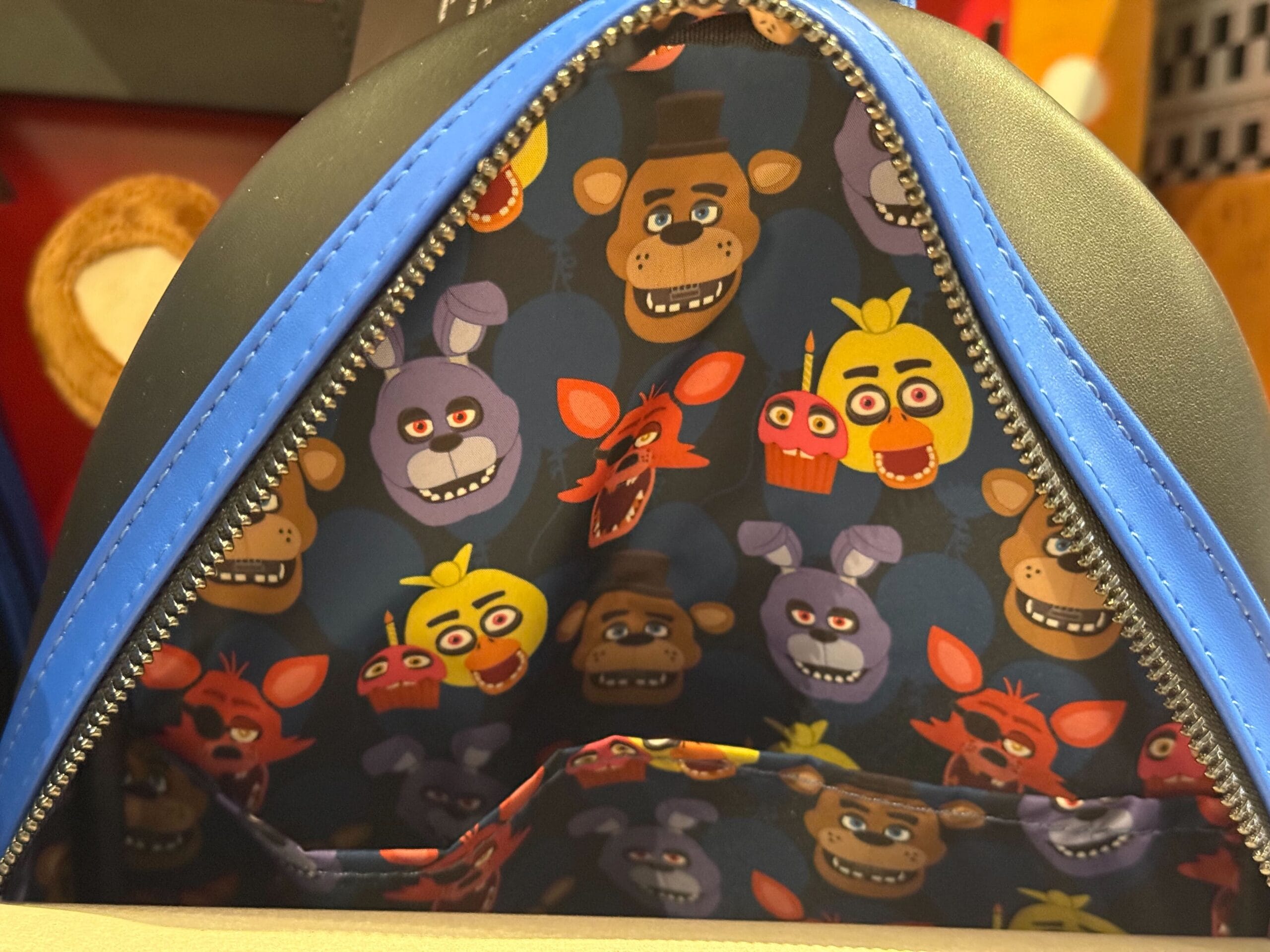 Blue bag with interior lining featuring cartoon animal faces; an adorable addition to your HHN Merch 2025 collection.