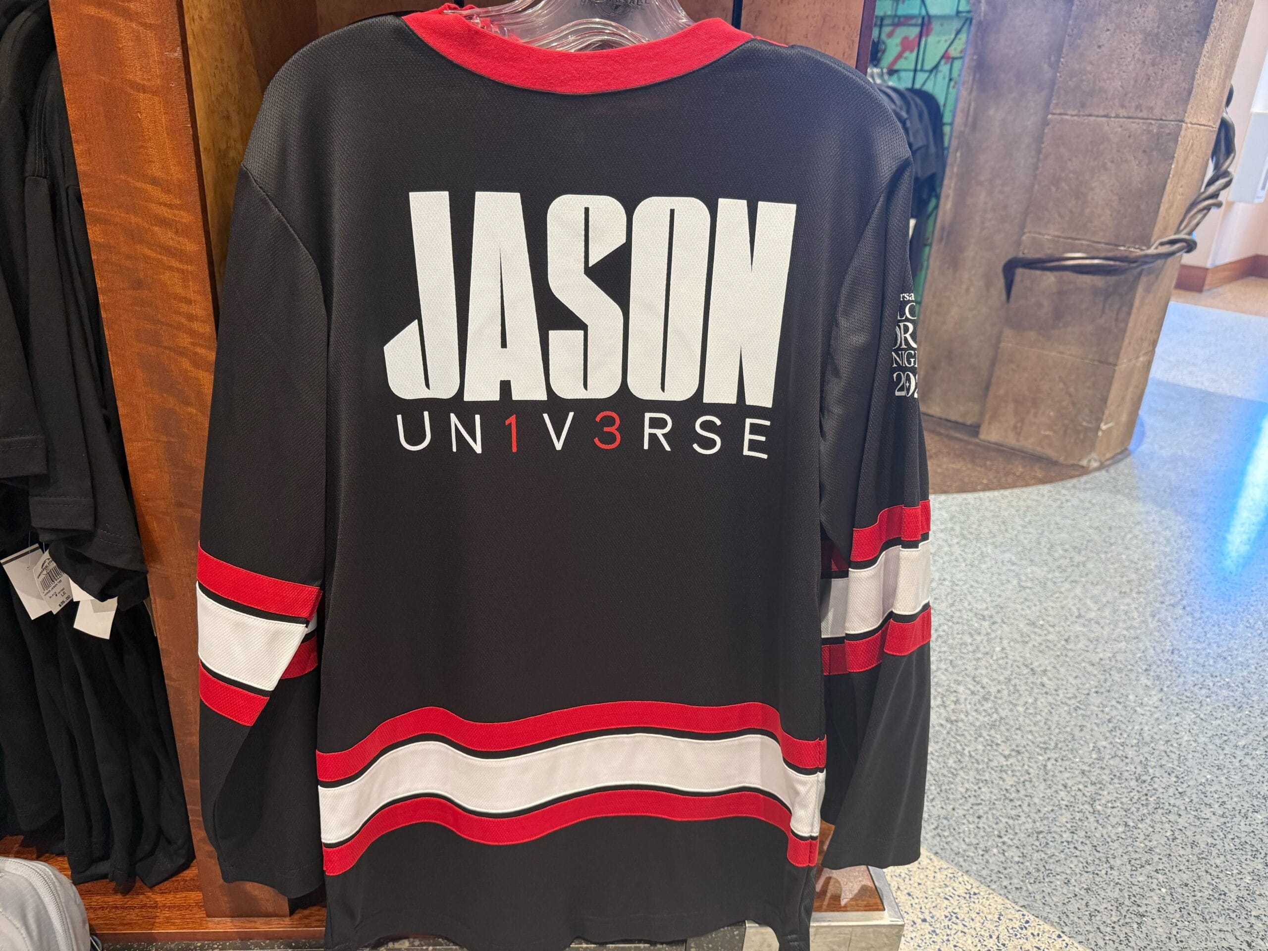 Black shirt with red and white stripes—"JASON UN1V3RSE" on back—an exclusive HHN Merch 2025 at Universal Studios Hollywood.