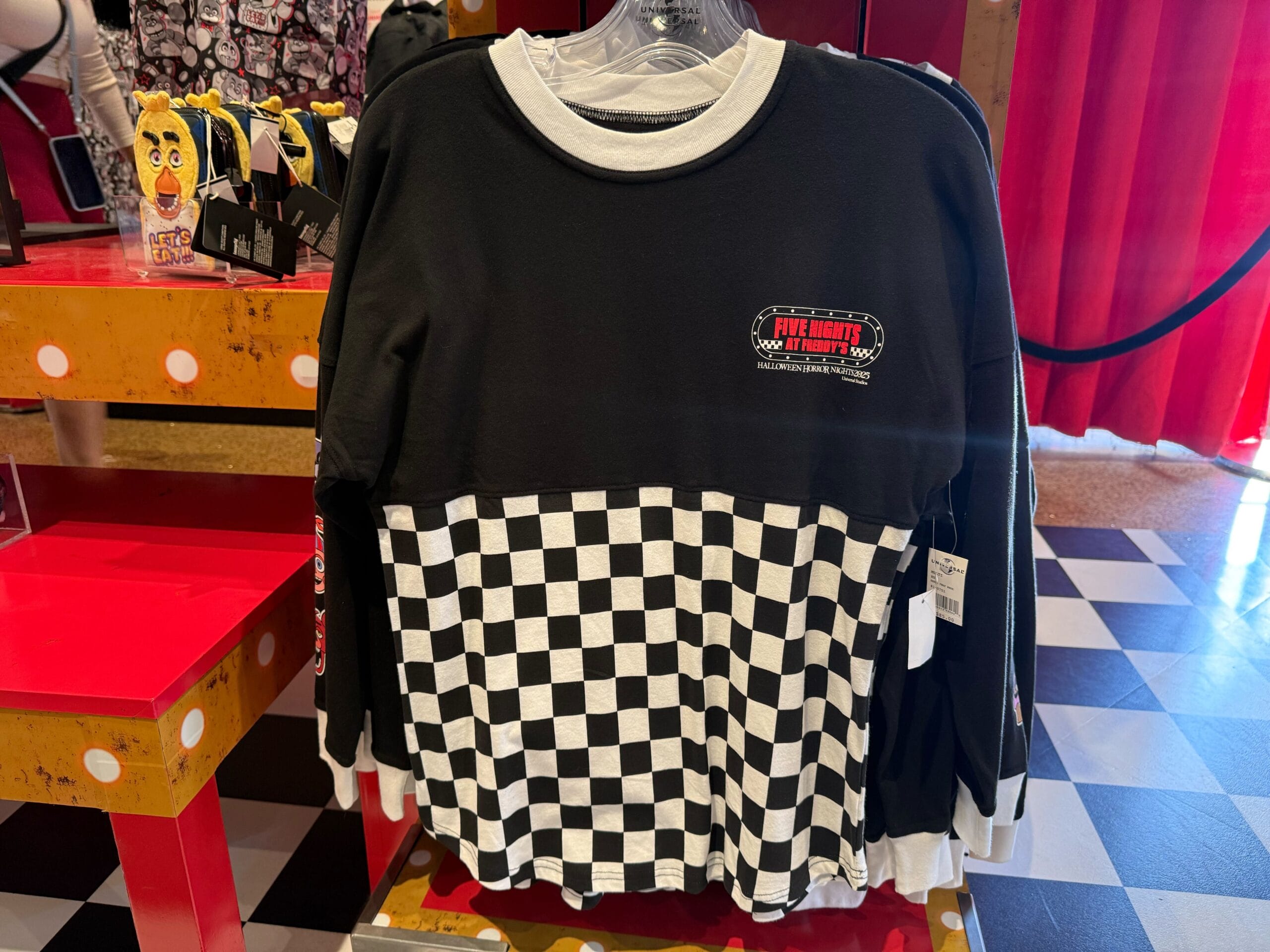 A black and white checkered long-sleeve Five Nights at Freddy’s shirt, perfect for Universal Studios Hollywood fans.