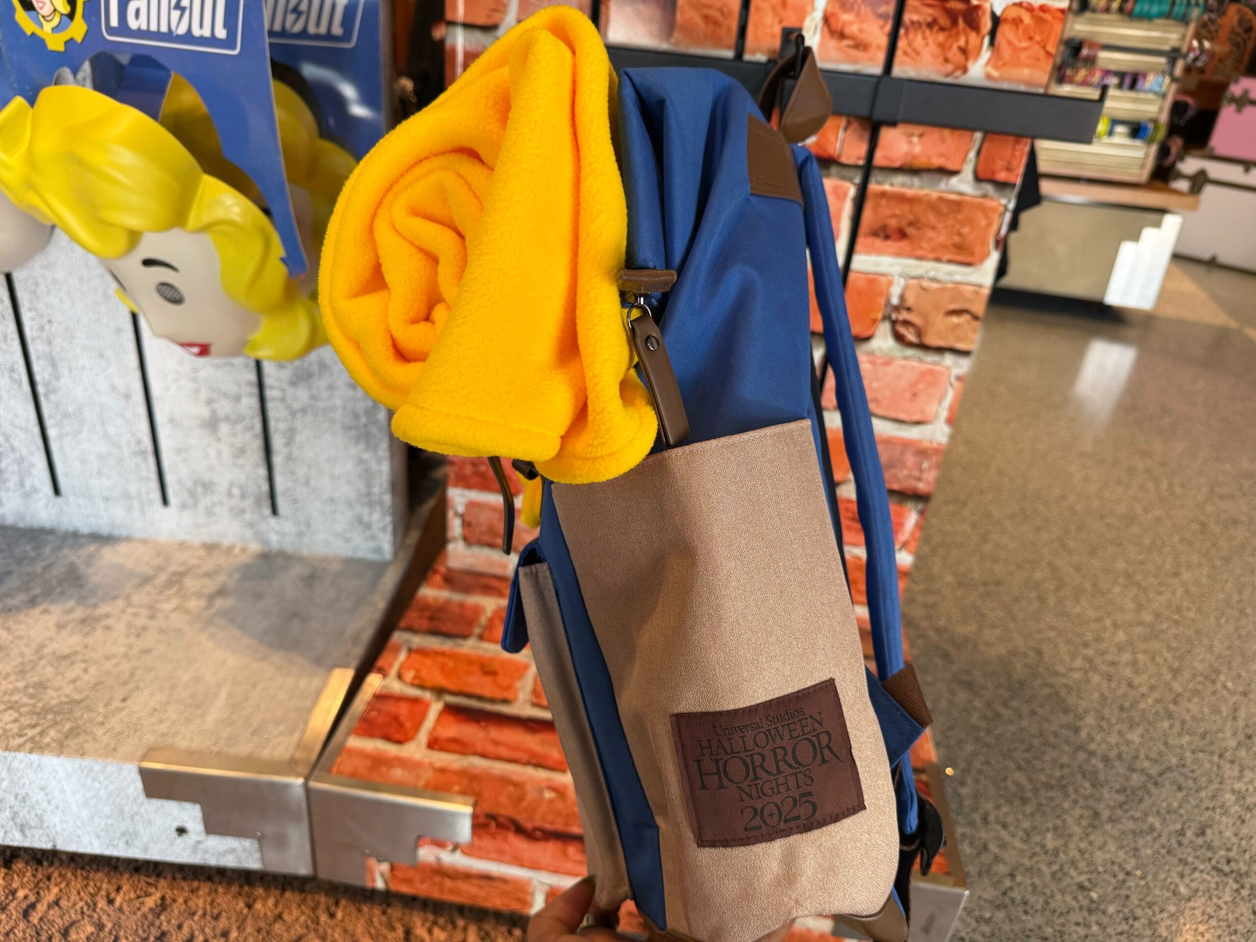 A blue and tan backpack with a "Halloween Horror Nights 2023" patch—perfect Universal Studios Hollywood merchandise.