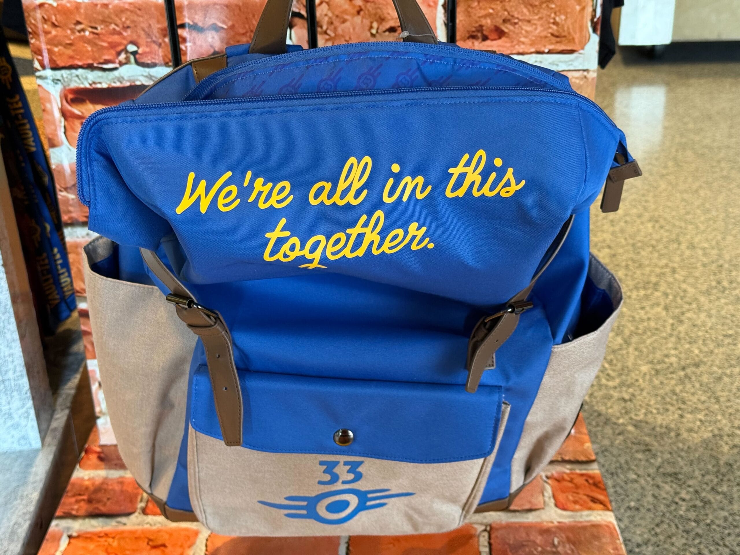 Blue and tan backpack with "We're all in this together," part of the HHN Merch 2025 at Universal Studios Hollywood.