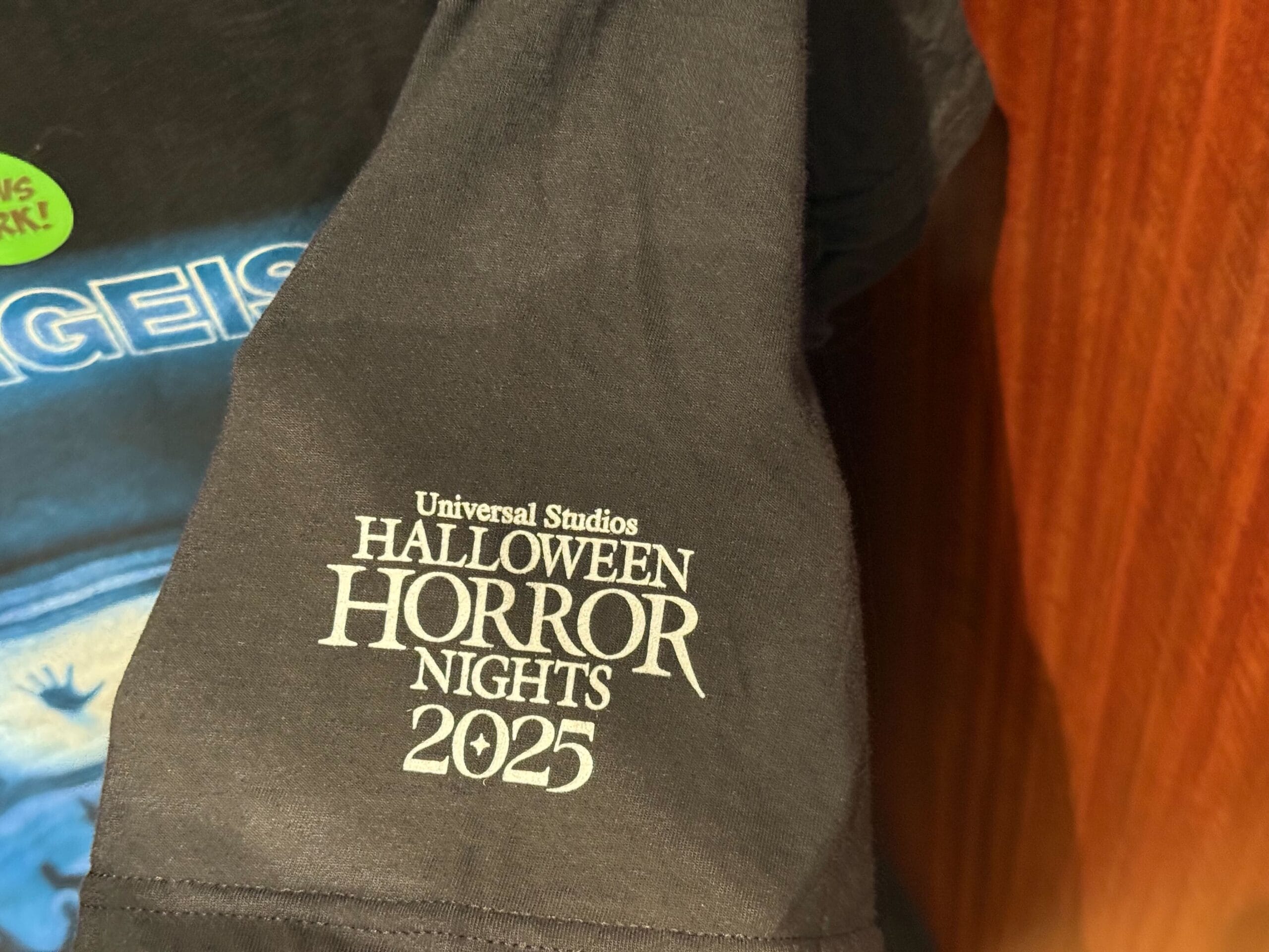 Close-up of a black T-shirt from Universal Studios Hollywood, featuring Halloween Horror Nights Merchandise for 2025.