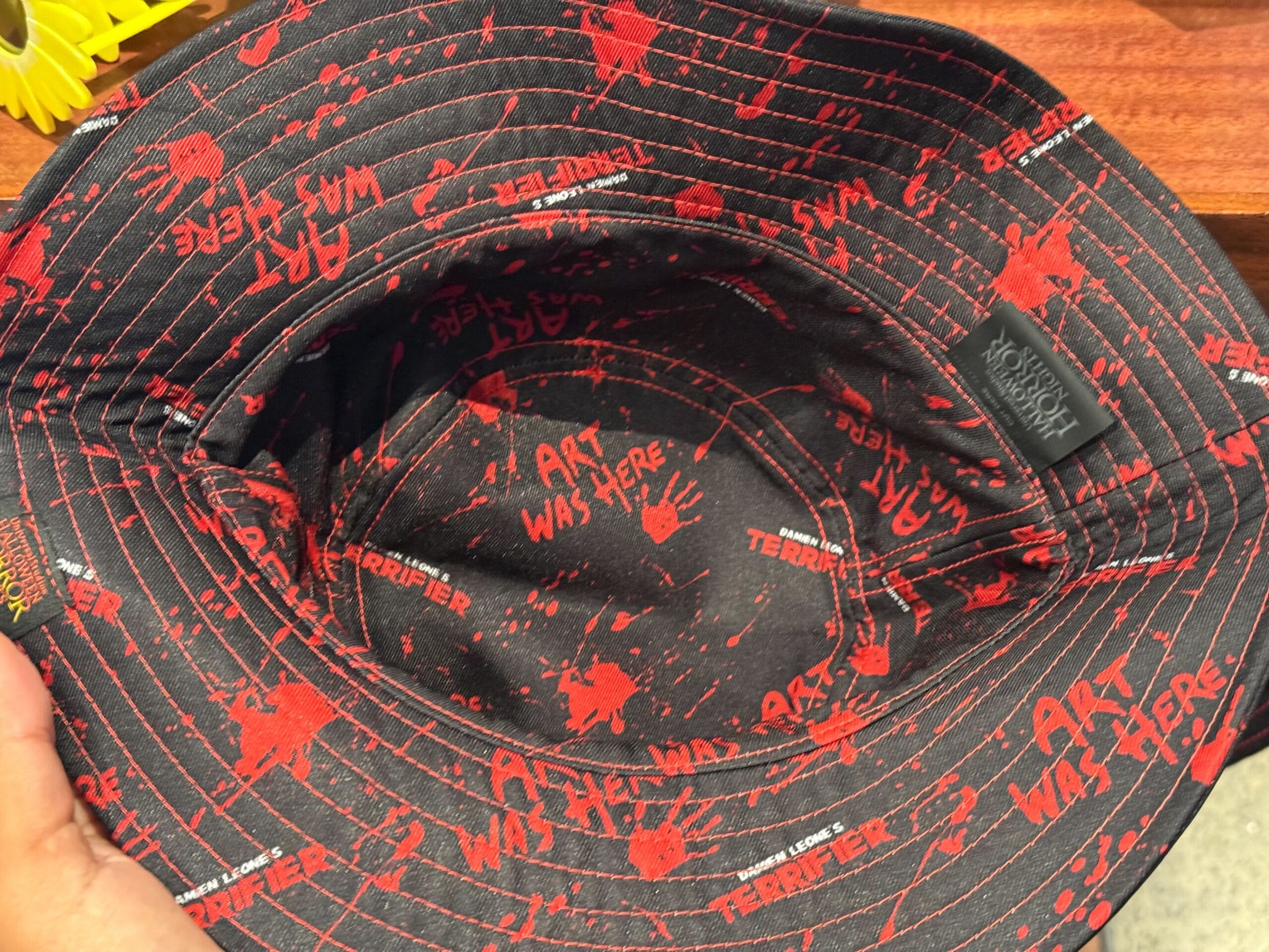 Black bucket hat with red splatters, "ART WAS HERE" and "TERRIFIER"—perfect HHN Merch 2025 at Universal Studios Hollywood.