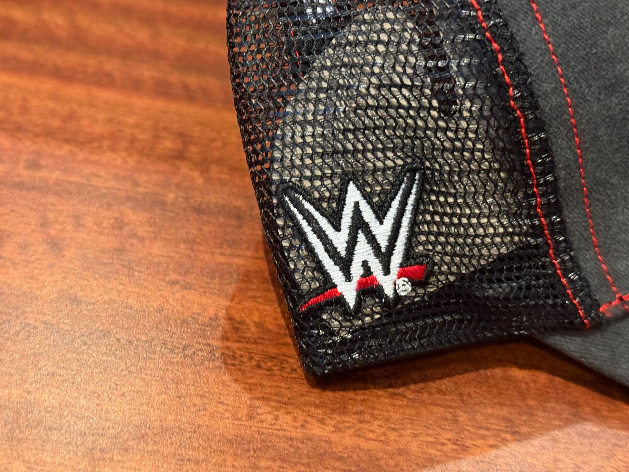 A black mesh cap with a WWE logo, perfect for Universal Studios Hollywood or Halloween Horror Nights Merchandise fans.