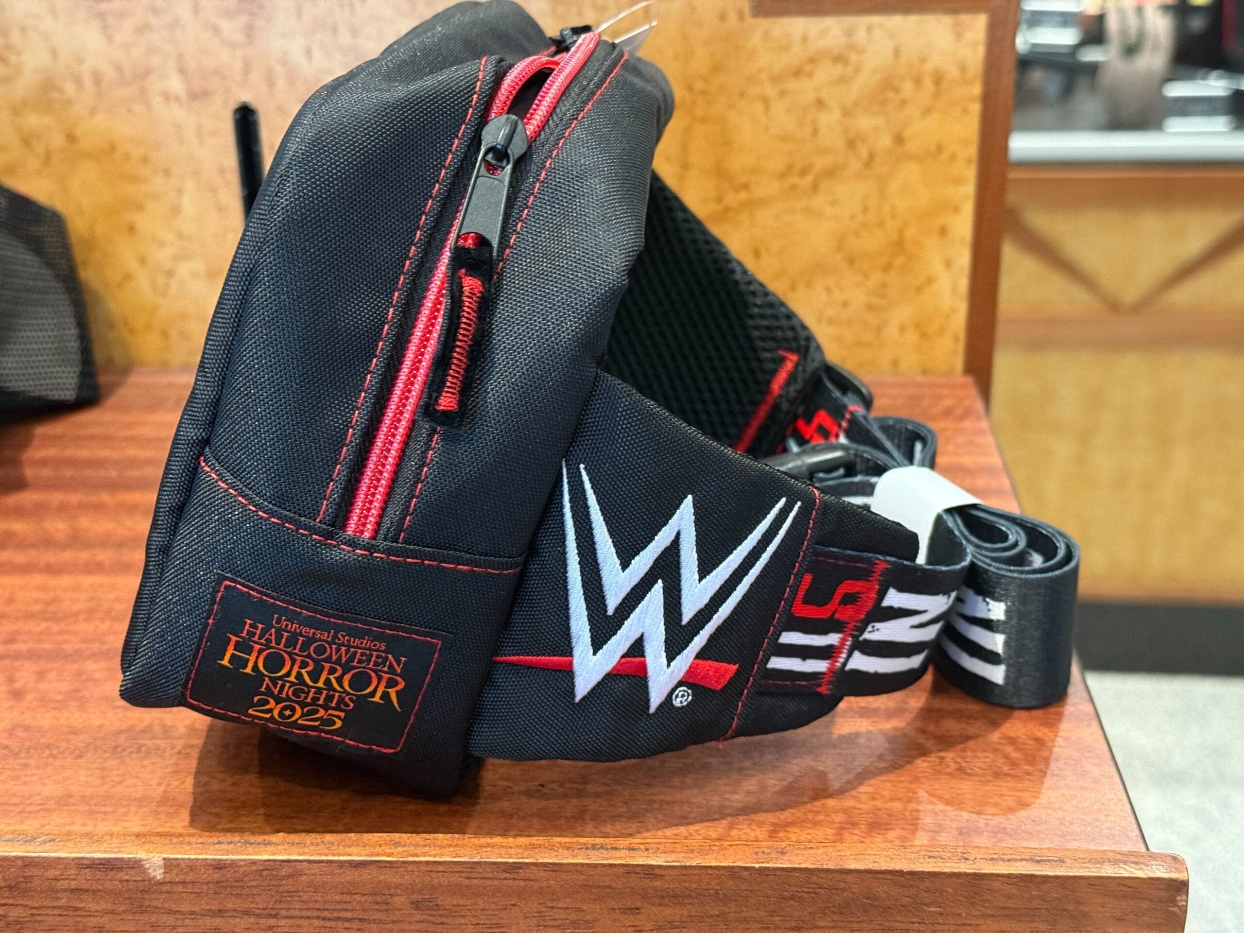 Black WWE-themed fanny pack with a Halloween Horror Nights 2025 patch, perfect for HHN Merch 2025 fans.