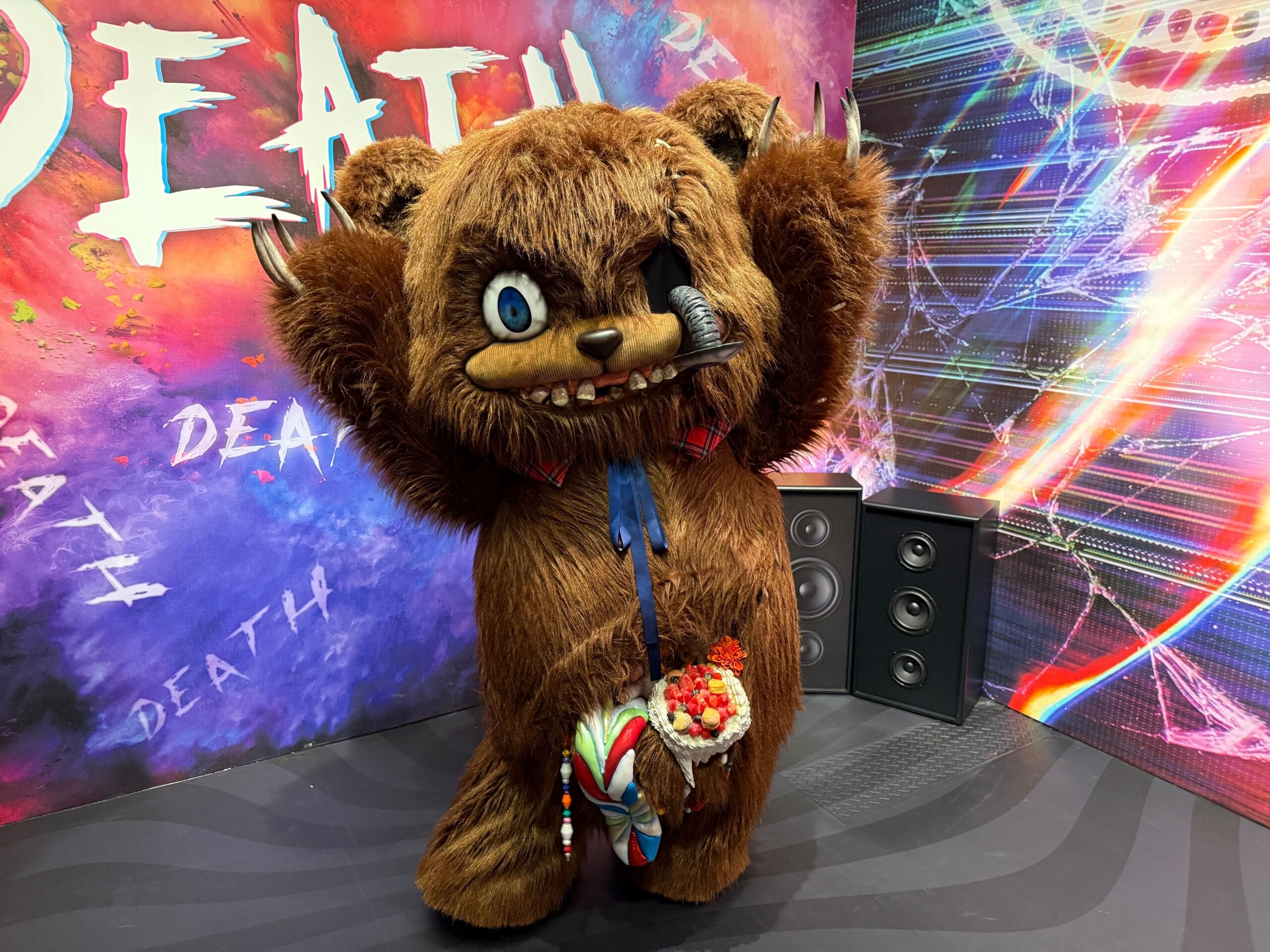A creepy HamiKuma bear costume with sharp teeth stands on stage at Universal Studios Japan’s Halloween Horror Nights.