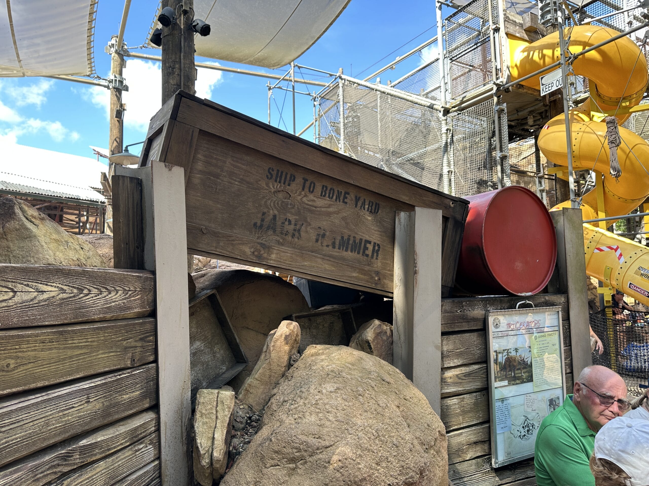 Wooden sign reading "Ship to Bone Yard, Jack Hammer," surrounded by rocks, barrels, and playground equipment.