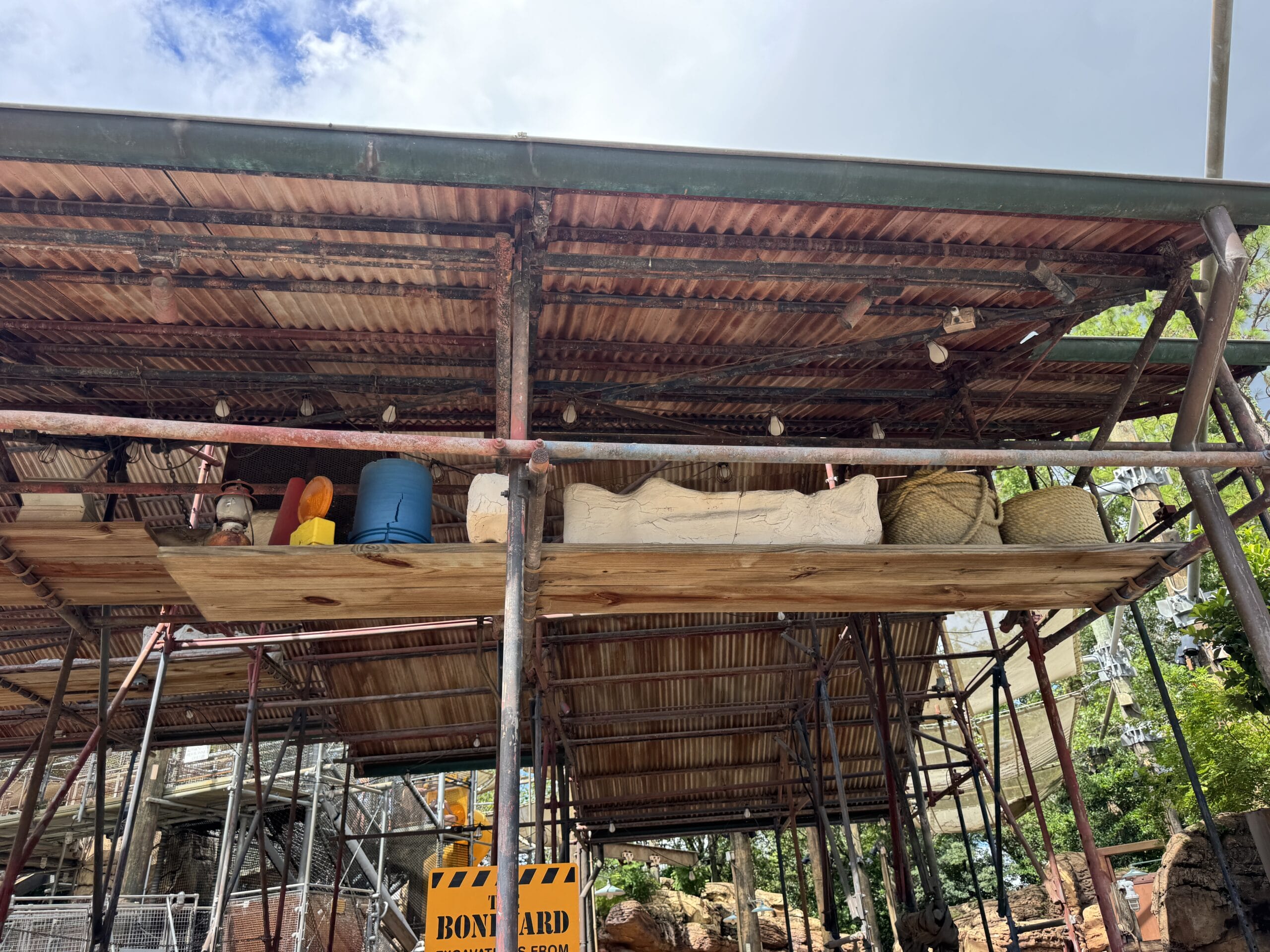 Scaffolding with a corrugated roof and crates in The Boneyard at Disney's Animal Kingdom; "Boundary" sign below.