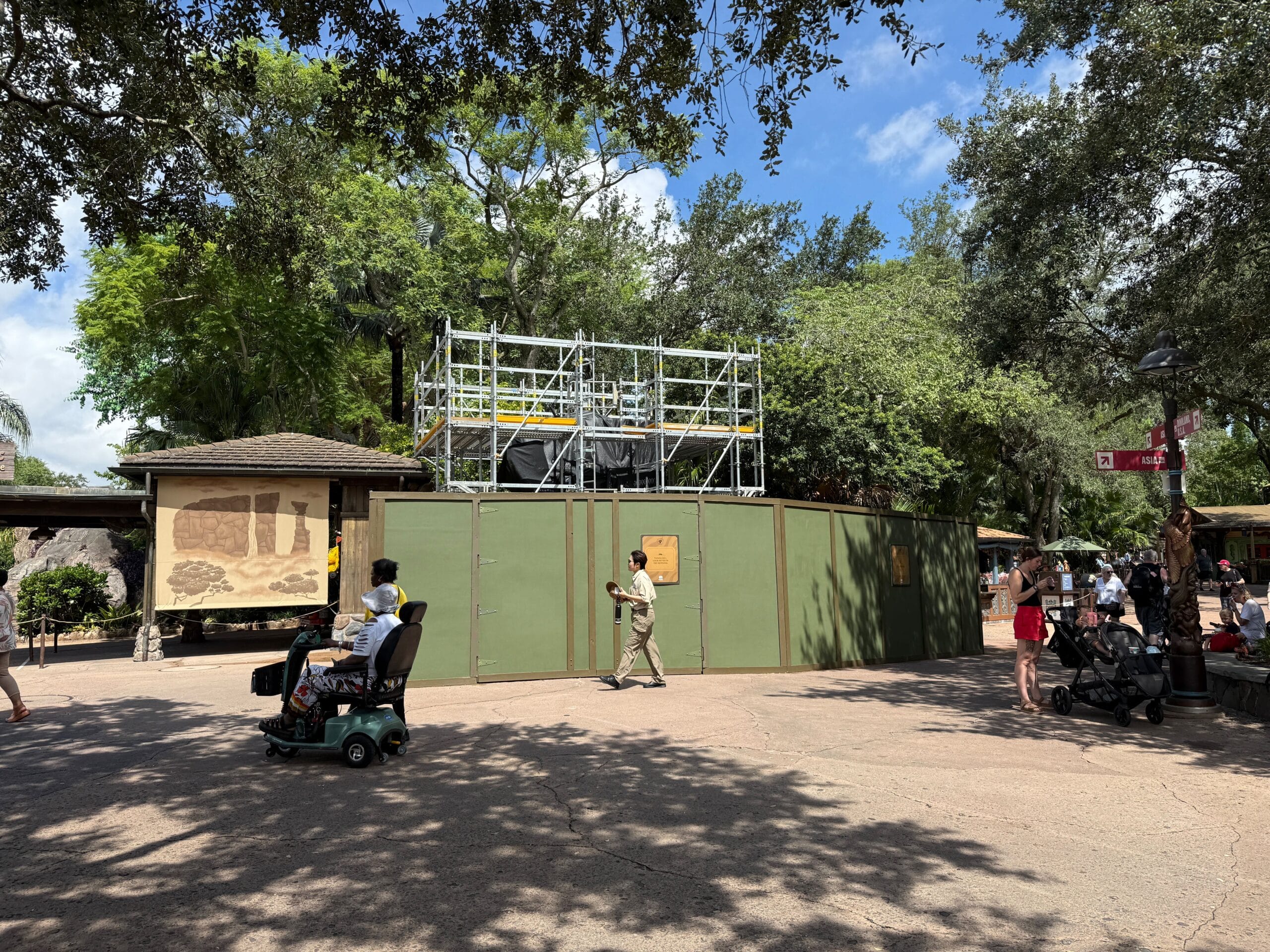 Construction walls with a Better Zoogether sign surround a building at Disney's Animal Kingdom on a sunny day.
