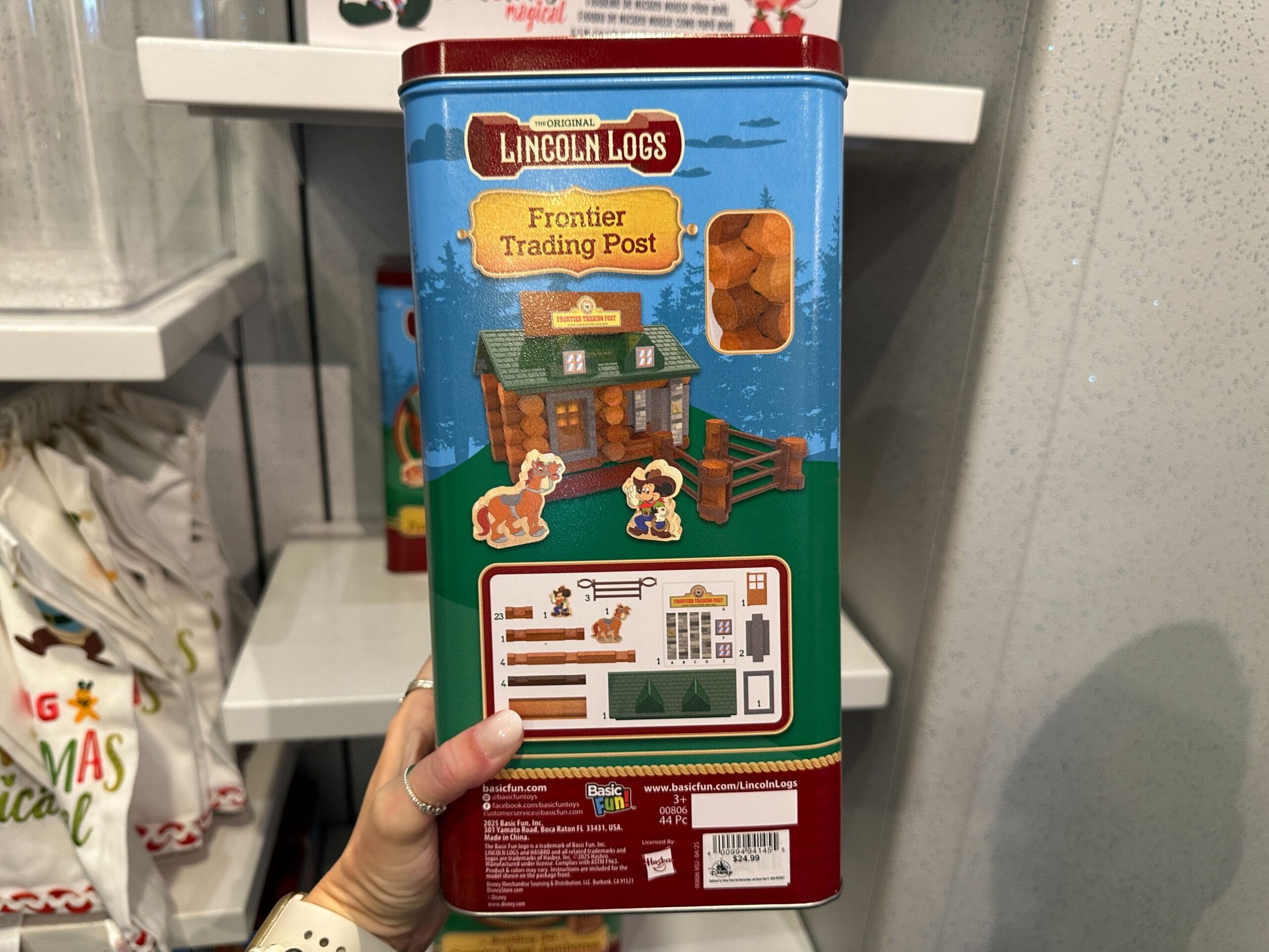 A hand holds a Lincoln Logs Frontier Trading Post set, showing the box’s front with illustrations and contents.