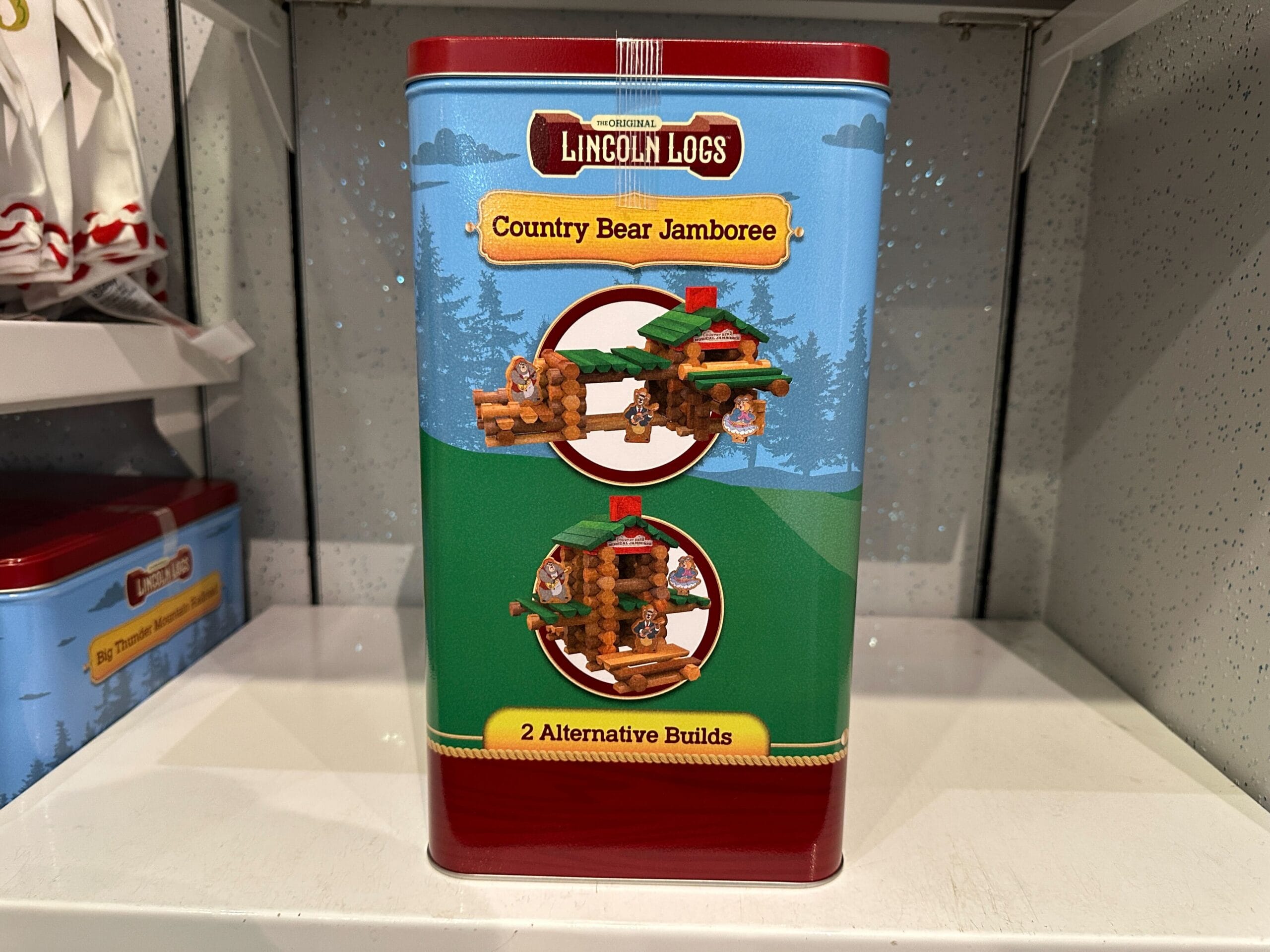 Lincoln Logs "Country Bear Jamboree" tin showing two alternative build designs on a store shelf.
