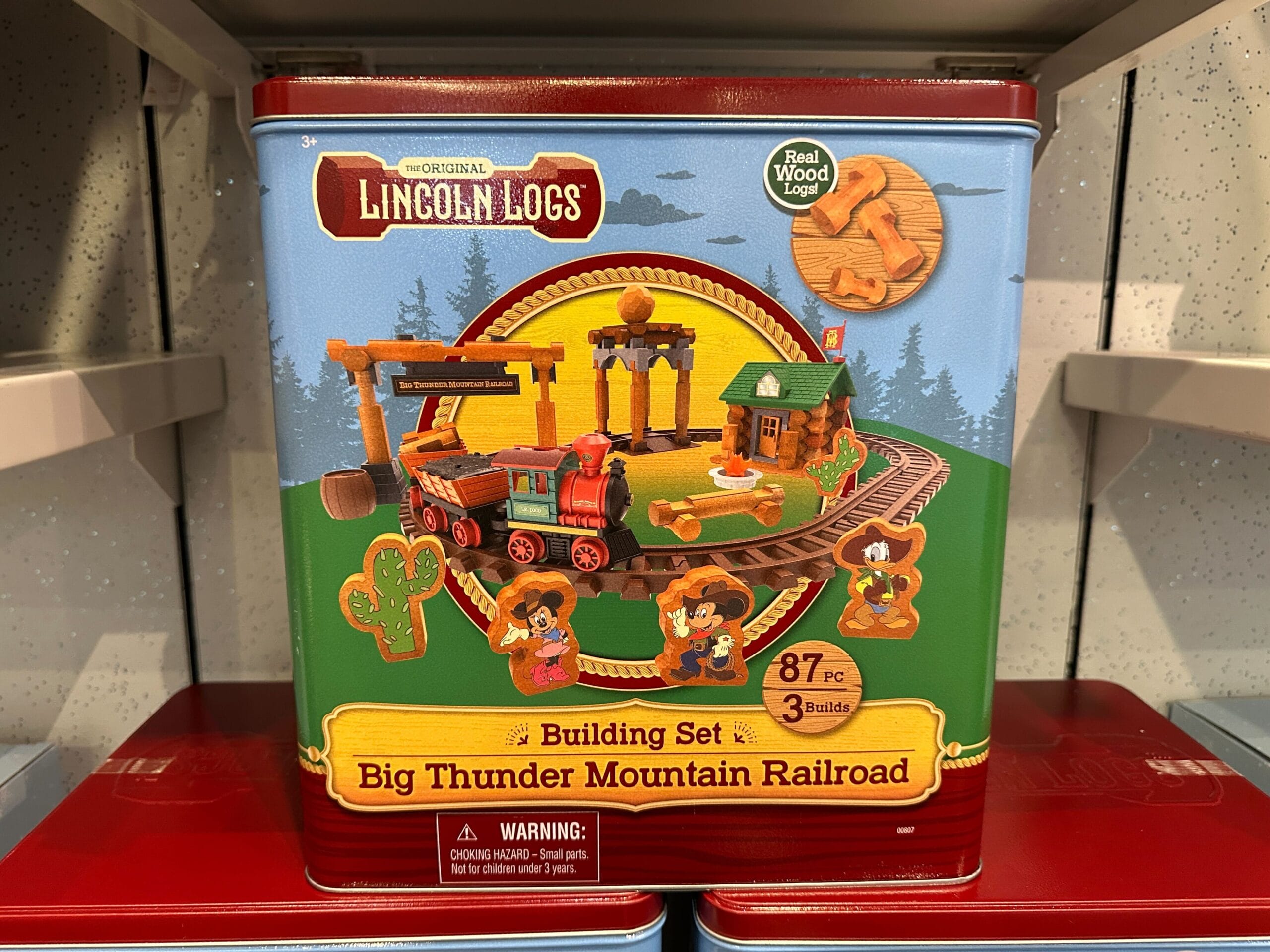 Lincoln Logs Big Thunder Mountain Railroad building set tin with a train and characters illustrated on the front.