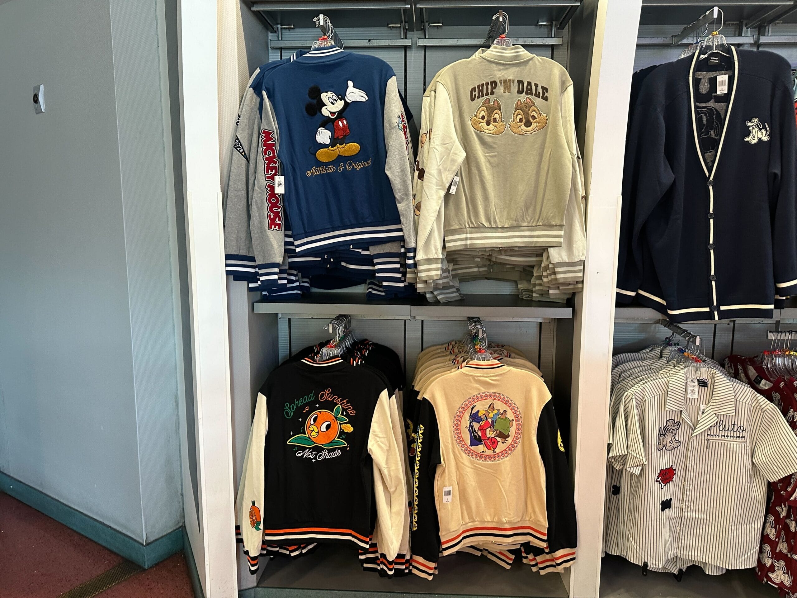 Disney Letterman Jackets featuring Mickey Mouse, Chip 'n' Dale, and Orange Bird are displayed on the shelves.