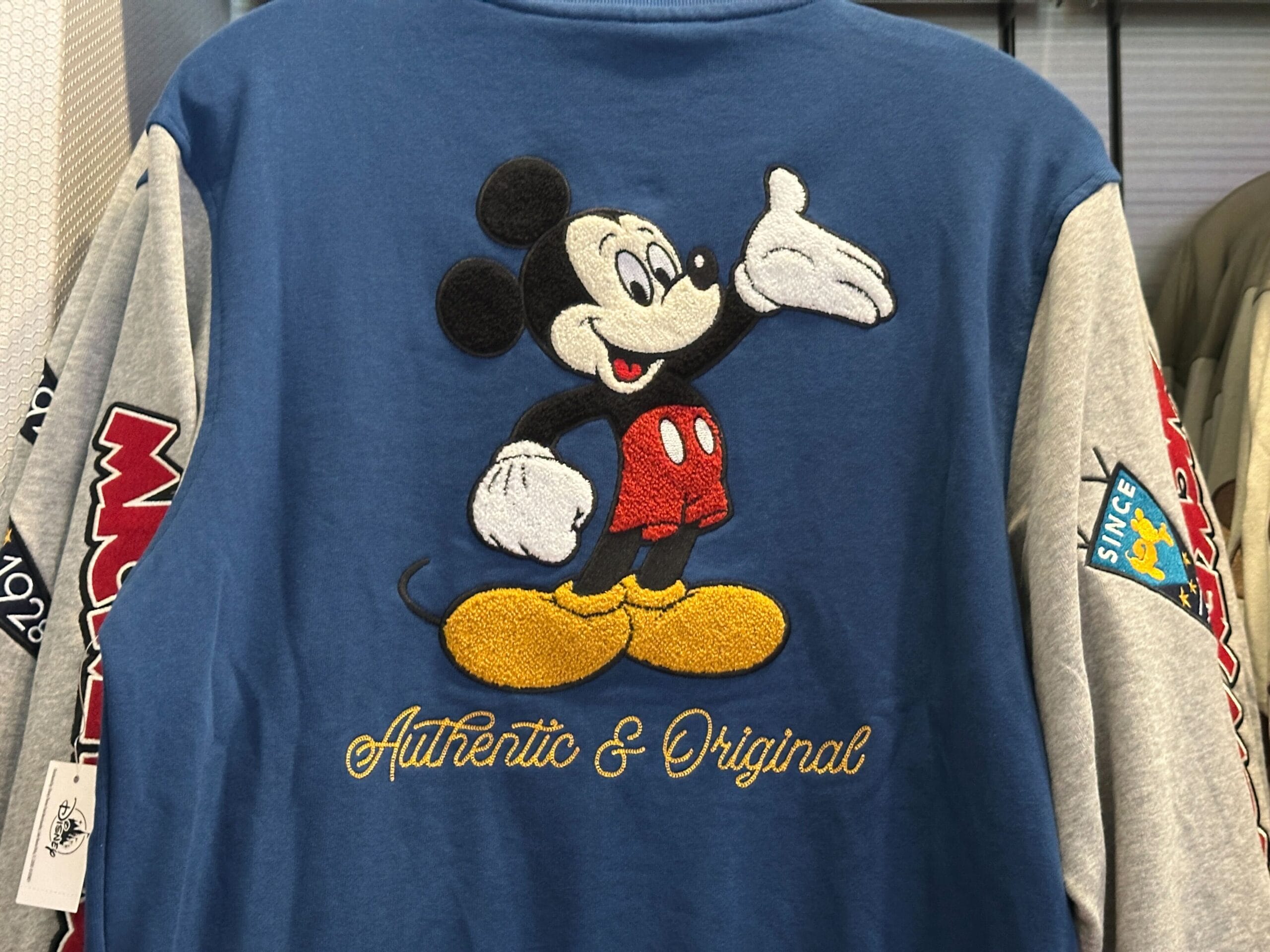 Blue and gray Disney Letterman Jacket featuring Mickey Mouse embroidery and "Authentic & Original" on the back.