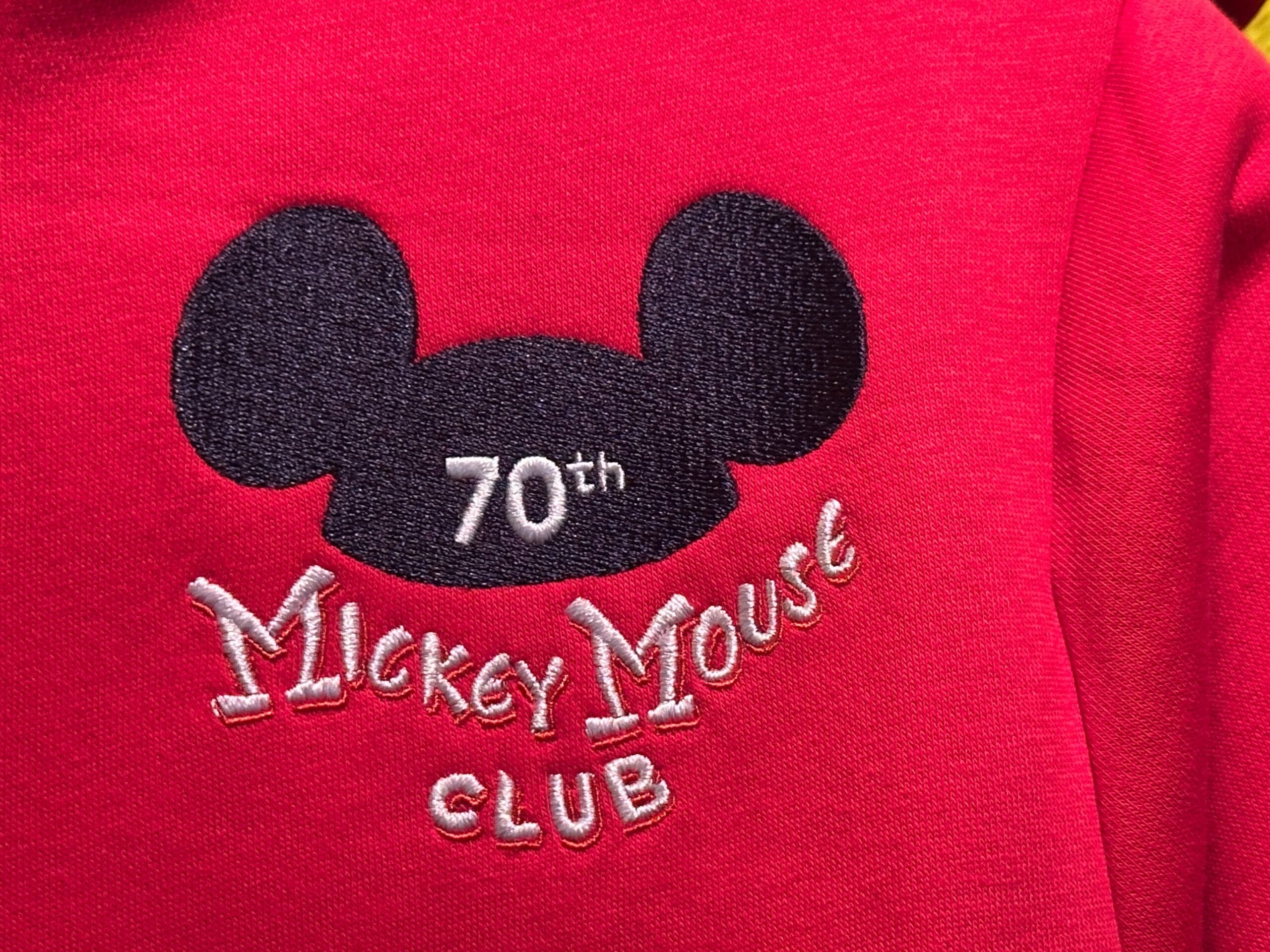 Red fabric with a black Mickey Mouse ears hat and white text reading "70th Mickey Mouse Club.