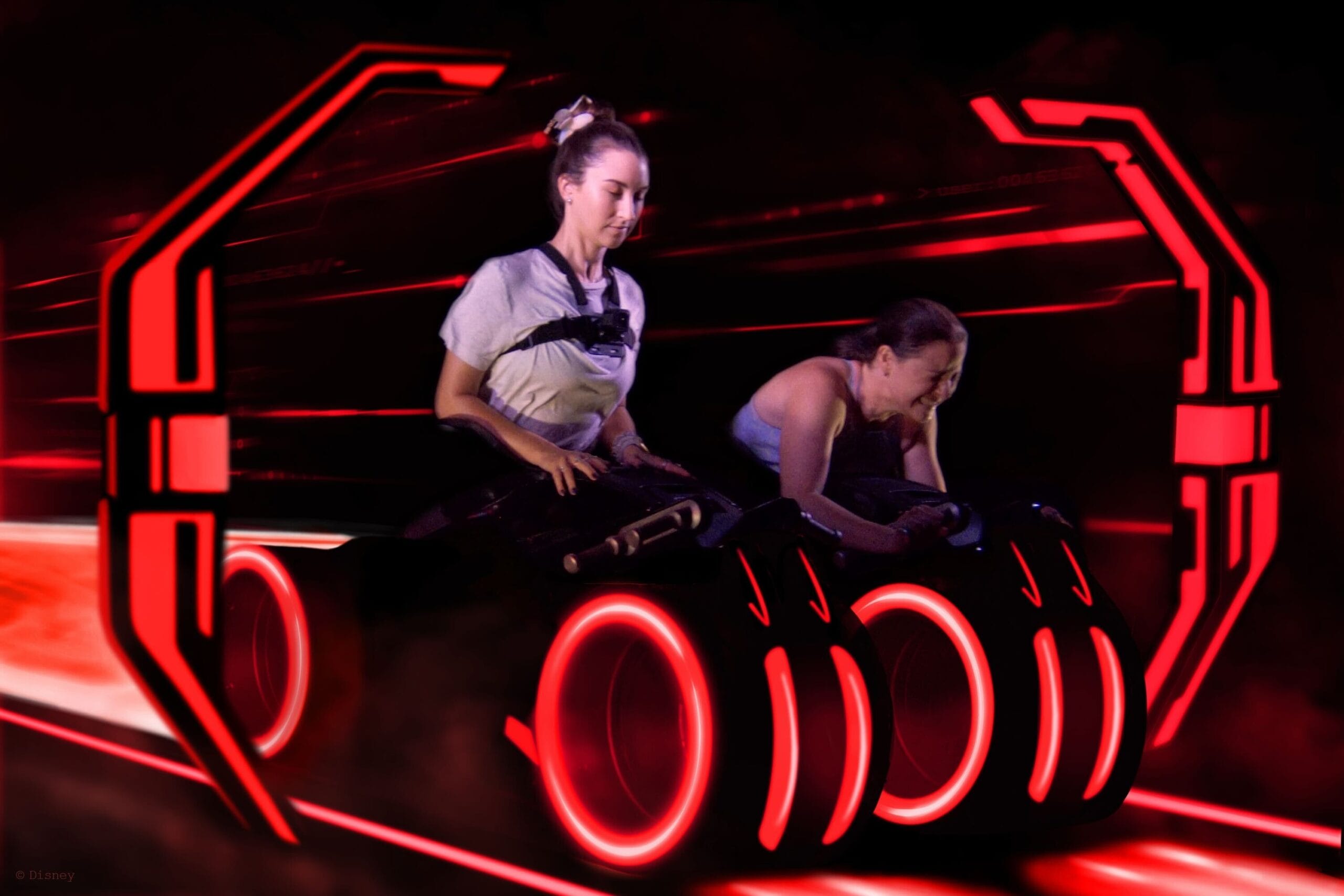 Two women riding a glowing red light cycle in a sci-fi TRON Overlay with a Nine Inch Nails soundtrack.