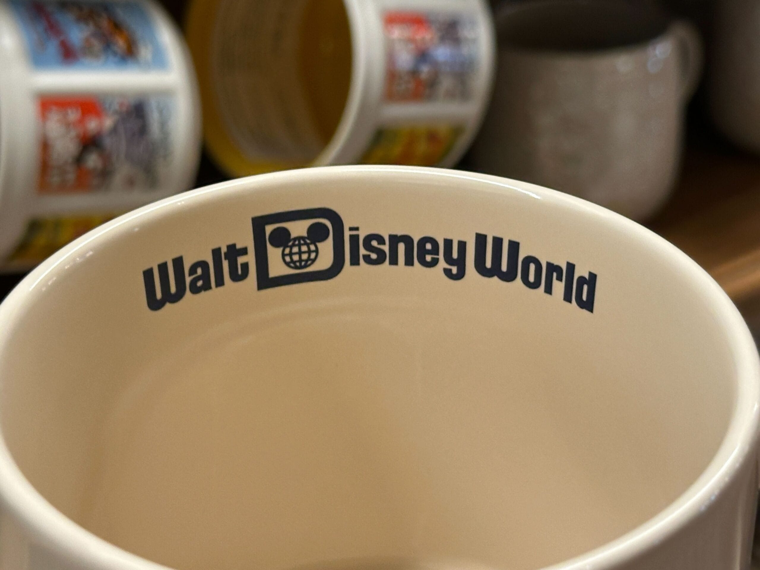 Close-up of a mug with "Walt Disney World" and a Mickey Mouse-inspired globe logo printed on the inside rim.