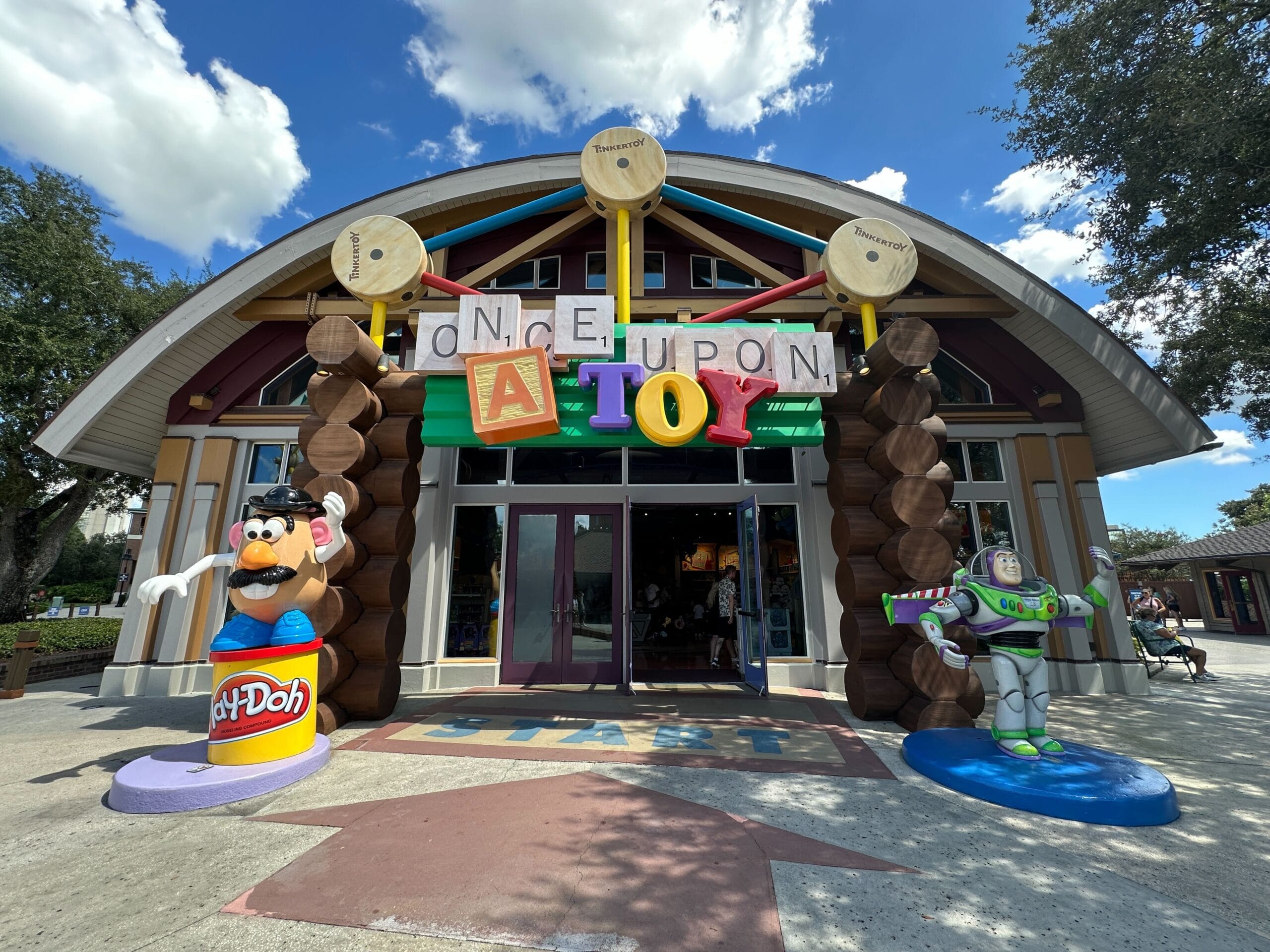 Storefront of "Once Upon a Toy" with large toy figures, Mr. Potato Head and Buzz Lightyear, at the entrance.
