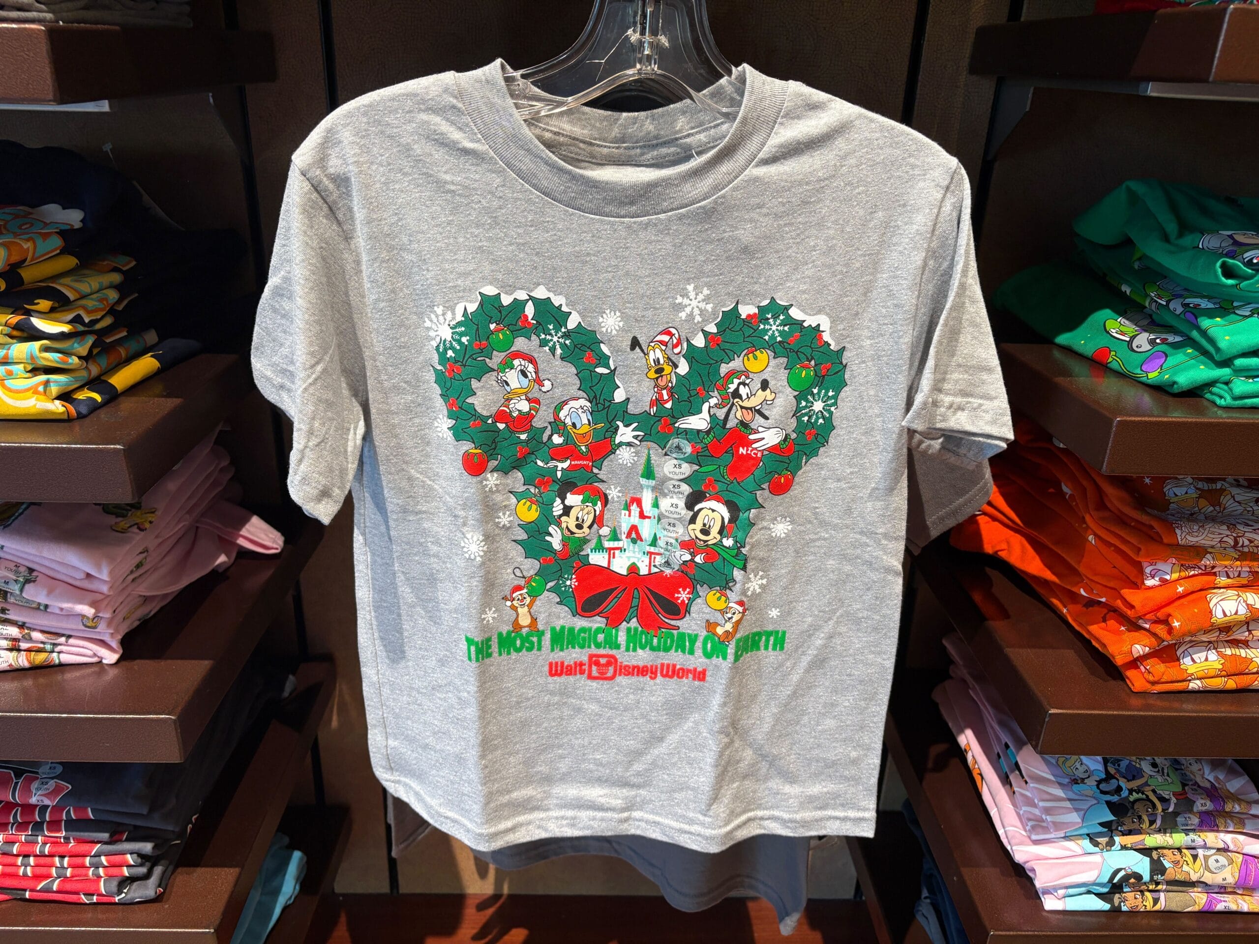 Gray Disney World holiday shirt with Mickey, Minnie, Donald, Daisy, and Goofy inside a wreath shaped like Mickey ears.