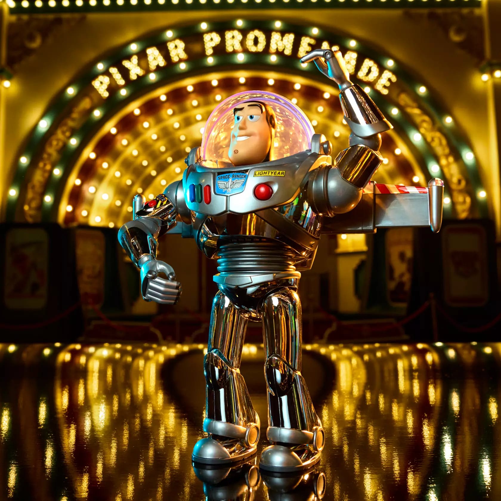 A shiny metallic Buzz Lightyear toy stands by the glowing "Pixar Promenade" sign at Disney, marking Toy Story's 30 years.