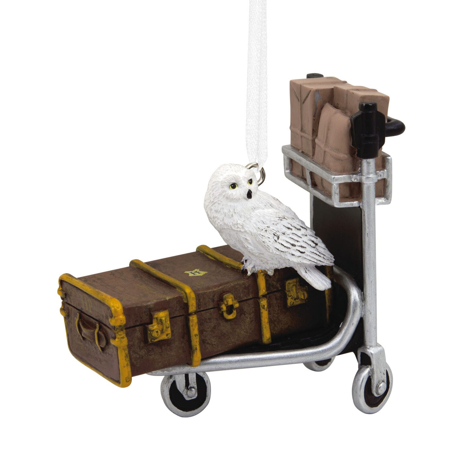 A small owl figurine perched on a luggage cart with parcels