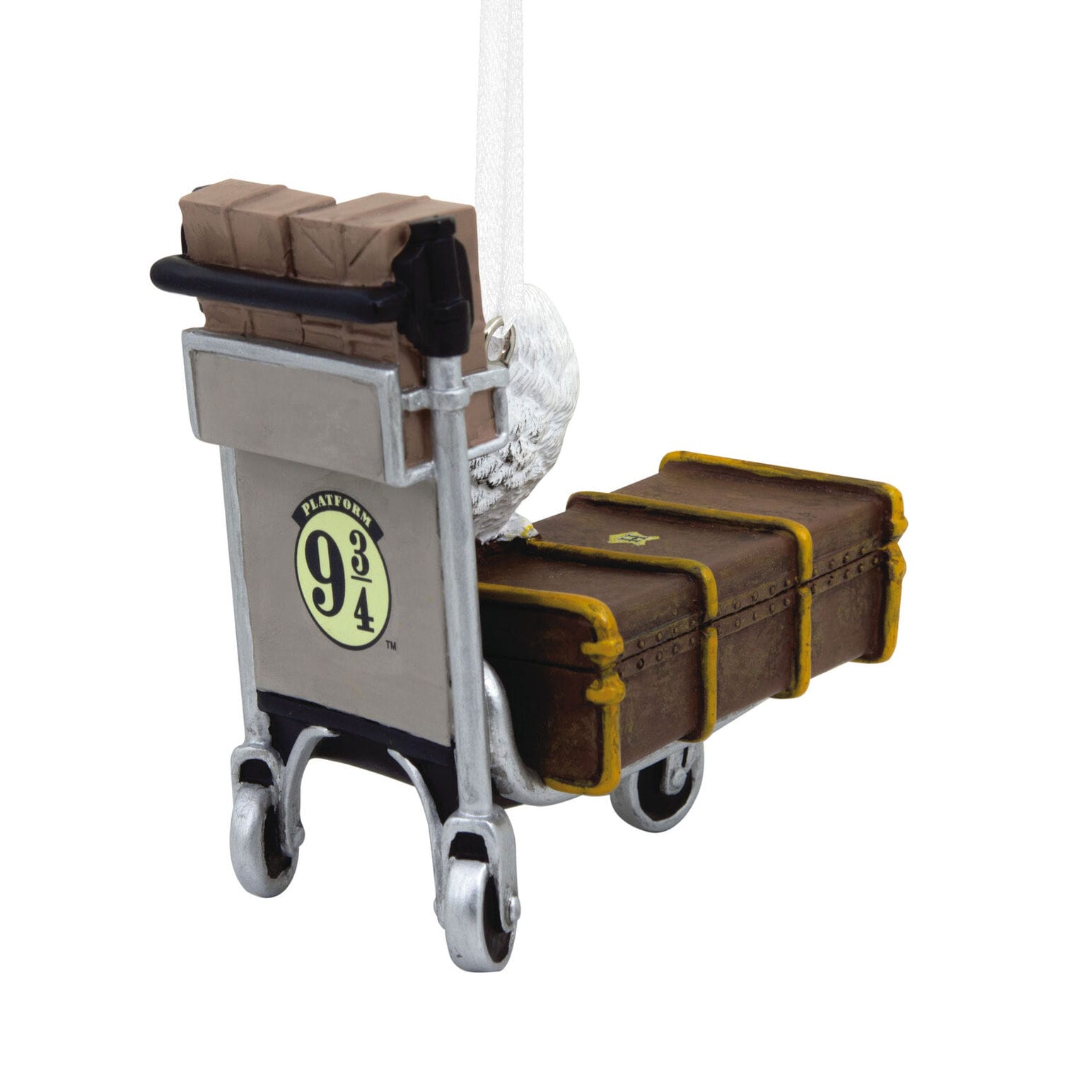A luggage cart with suitcases and an owl cage near a Platform 9 3/4 sign